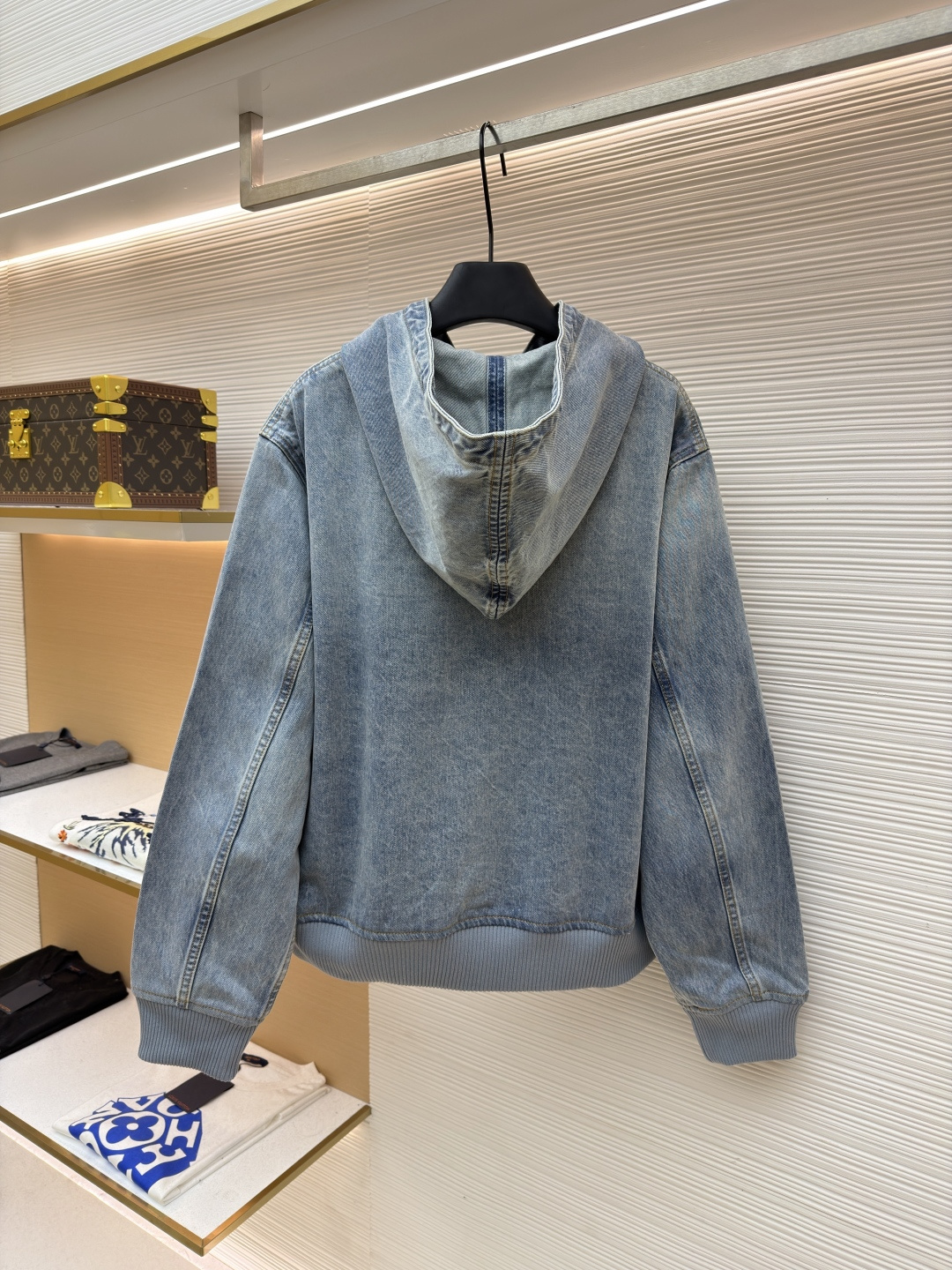 P360 LOUIS VUITTON 口袋字母刺绣连帽牛仔外套
●原版：21579购入开发
●货号：1682616-C25
●面料：牛仔面料
●工艺：刺绣制作
●颜色：洗水蓝
●版型：合身版型
●克重：约1390克
●尺码：46-48-50-52
●描述：这件LOUIS VUITTON连帽抽绳拉链徽标刺绣工装长袖牛仔外套，选用重磅复古水洗牛仔布打造，经过多道酵洗与石磨工艺，呈现自然柔和的浅蓝褪色效果与细腻做旧纹理。外套采用宽松落肩版型，搭配罗纹收边袖口与下摆，兼顾复古工装感与日常穿着舒适度。连帽设计配备同色系抽绳，金属拉链头镌刻品牌标识，前幅立体贴袋处饰有低调的LV刺绣徽标，袋口以金属铆钉加固，兼具装饰性与耐用性。内里采用格纹棉质面料提升穿着体验，每一处缝线都经过精细处理，既保留了牛仔的硬朗质感，又融入了LV标志性的精致细节，是打造随性街头造型的高阶选择。整体走线平直细腻，面料舒适柔软，颜色一致无色差 能与同款搭配营造时尚造型，驾驭各种场合，定制辅料，三标齐全，男女同款！