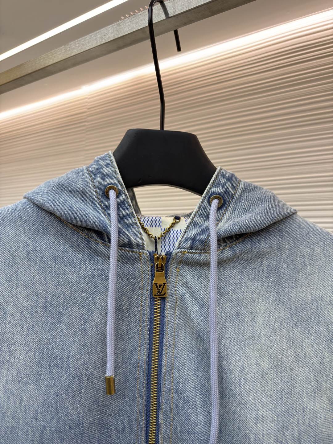 P360 LOUIS VUITTON 口袋字母刺绣连帽牛仔外套
●原版：21579购入开发
●货号：1682616-C25
●面料：牛仔面料
●工艺：刺绣制作
●颜色：洗水蓝
●版型：合身版型
●克重：约1390克
●尺码：46-48-50-52
●描述：这件LOUIS VUITTON连帽抽绳拉链徽标刺绣工装长袖牛仔外套，选用重磅复古水洗牛仔布打造，经过多道酵洗与石磨工艺，呈现自然柔和的浅蓝褪色效果与细腻做旧纹理。外套采用宽松落肩版型，搭配罗纹收边袖口与下摆，兼顾复古工装感与日常穿着舒适度。连帽设计配备同色系抽绳，金属拉链头镌刻品牌标识，前幅立体贴袋处饰有低调的LV刺绣徽标，袋口以金属铆钉加固，兼具装饰性与耐用性。内里采用格纹棉质面料提升穿着体验，每一处缝线都经过精细处理，既保留了牛仔的硬朗质感，又融入了LV标志性的精致细节，是打造随性街头造型的高阶选择。整体走线平直细腻，面料舒适柔软，颜色一致无色差 能与同款搭配营造时尚造型，驾驭各种场合，定制辅料，三标齐全，男女同款！