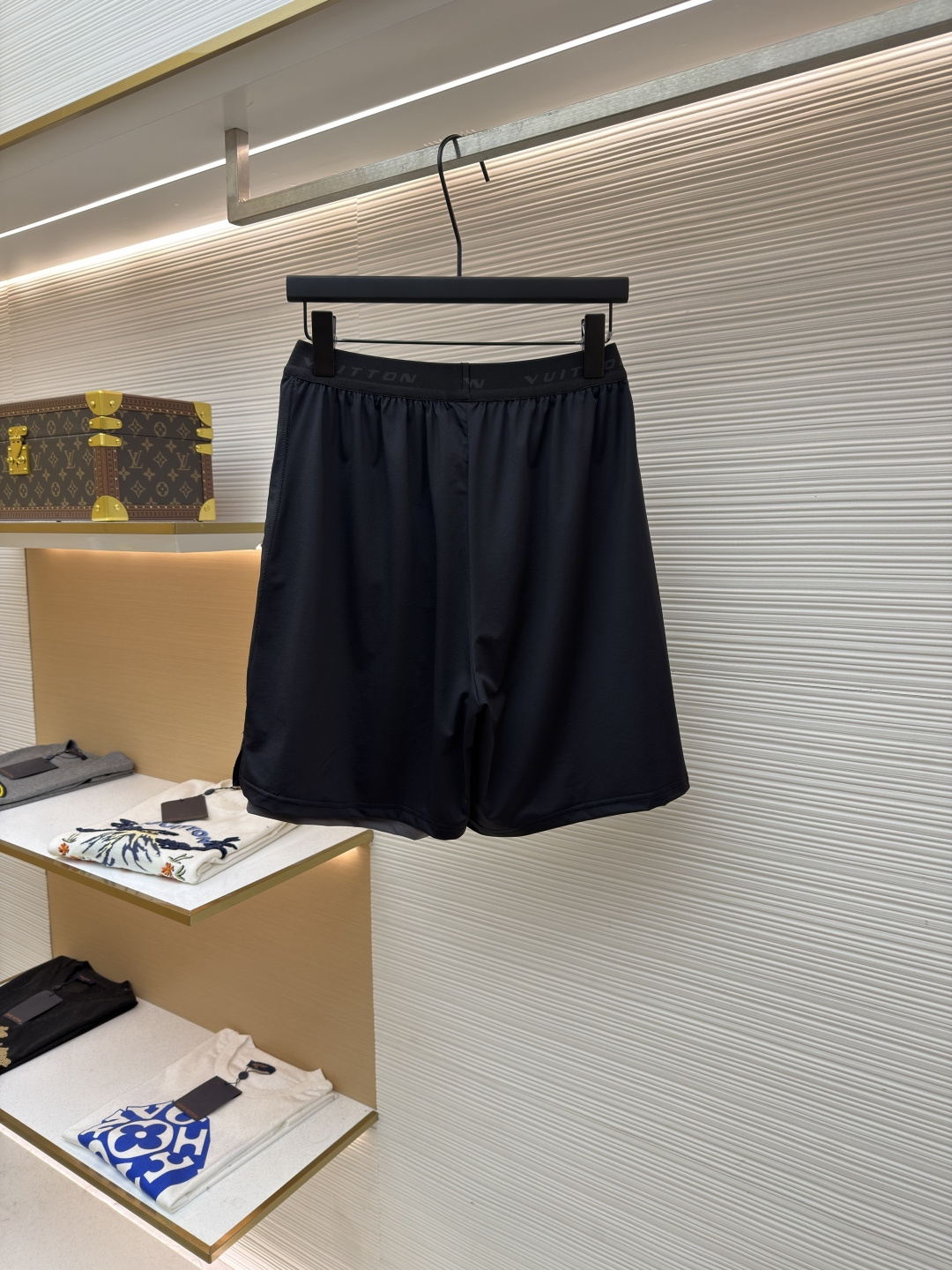 P205 LOUIS VUITTON 双层松紧腰拉链侧袋徽标运动短裤
●原版：9350购入开发
●货号：1682617-A75
●面料：速干面料
●工艺：定位裁床制作
●颜色：黑色
●版型：合身版型
●克重：约285克
●尺码：S-M-L-XL
●描述：这款LV男士短裤采用高密锦纶速干面料，兼具挺括质感与透气性能，面料经抗皱、抗静电处理，日常穿着不易起球变形。腰头采用双层弹力织带设计，织带表面采用立体压印工艺呈现品牌标识，既强化品牌辨识度，又保证了穿着的贴合度与舒适度。裤身采用双线包边工艺，侧缝隐藏式口袋运用激光切割与高温热压技术封边，边缘平整无毛边。裤脚采用撞色包边设计，与腰头形成视觉呼应，裤腿外侧的LV标识采用硅胶立体烫印工艺，触感饱满且不易脱落，整体工艺兼具实用性与品牌标志性，满足日常休闲与轻运动场景需求。整体走线平直细腻，面料舒适柔软，颜色一致无色差 能与同款搭配营造时尚造型，驾驭各种场合，定制辅料，三标齐全，男女同款！