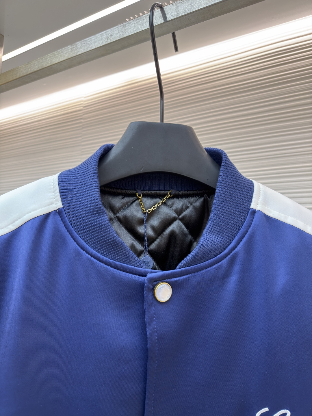 P325 LOUIS VUITTON 马年限定撞色饰带刺绣单排扣长袖夹克
●原版：27975购入开发
●货号：1682618-B90
●面料：全棉面料
●工艺：刺绣制作
●颜色：蓝白
●版型：合身版型
●克重：约1165克
●尺码：46-48-50-52
●描述：这款LV马年限定撞色饰带刺绣夹克，采用重磅哑光缎面面料，兼具挺括垂坠感与柔滑触感，表面经抗皱防泼水处理，日常打理便捷。立领与袖口、下摆采用高弹罗纹针织，紧密贴合且不易松弛变形，门襟选用定制哑光金属单排扣，扣面刻有品牌标识，兼具质感与辨识度。肩部与袖身的撞色饰带采用斜纹拼接工艺，边缘经包边处理避免脱线，左胸的品牌标识采用立体刺绣工艺，以多股线迹呈现饱满纹理，内里采用透气衬里，所有缝线处均做包边与锁边处理，整体工艺将传统棒球服版型与马年专属设计元素结合，兼具典藏价值与实穿性。整体走线平直细腻，面料舒适柔软，颜色一致无色差 能与同款搭配营造时尚造型，驾驭各种场合，定制辅料，三标齐全，男女同款！