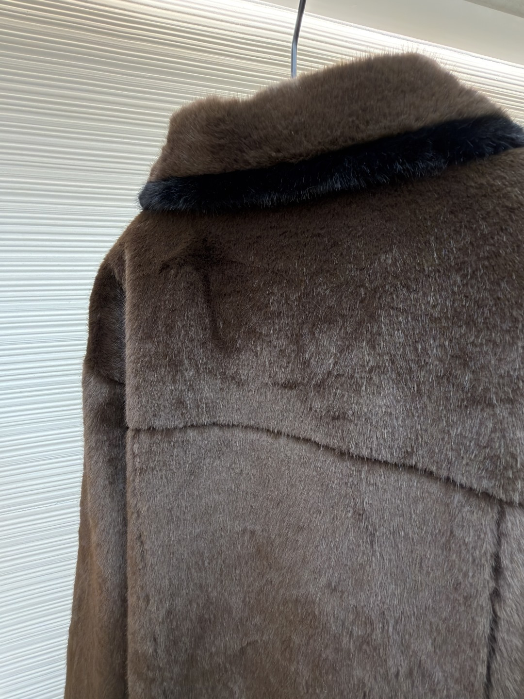 P455 LOUIS VUITTON 纯色长袖尖领皮草
●原版：171000购入开发
●货号：1682619-D15
●面料：水貂毛面料
●工艺：定位裁床制作
●颜色：棕色
●版型：合身版型
●克重：约1220克
●尺码：46-48-50-52
●描述：这款LV棕色仿水貂毛翻领夹克，采用高密仿水貂毛绒面料，绒毛浓密且富有光泽，触感柔软亲肤，兼具保暖性与高级质感。翻领设计沿用经典工装版型，领面与衣身采用同料一体剪裁，边缘经锁边处理防止脱线。门襟选用复古铜色金属按扣，扣面光滑且耐用，两侧翻盖口袋采用隐形缝线工艺，袋口的金属扣与门襟扣呼应，增强整体协调感。左胸的品牌标识牌采用真皮压印工艺，与毛绒面料形成材质对比，袖口与下摆的弹力包边紧密贴合身形，内里采用亲肤衬里避免静电，所有接缝处均做双针加固，兼顾保暖性与工装风格的硬朗质感，是冬季兼具造型感与实用性的单品。整体走线平直细腻，面料舒适柔软，颜色一致无色差 能与同款搭配营造时尚造型，驾驭各种场合，定制辅料，三标齐全，男女同款！