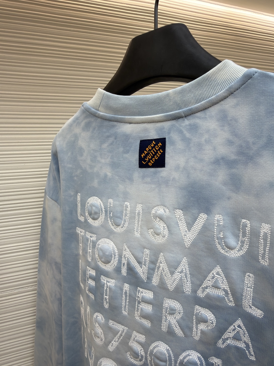 P205 LOUIS VUITTON 云朵扎染圆领卫衣
●原版：12883购入开发
●货号：1682620-A75
●面料：全棉面料
●工艺：扎染漂白制作
●颜色：蓝白
●版型：合身版型
●克重：约550克
●尺码：XS-S-M-L
●描述：面料采用26S双纱+10S鱼鳞底磨毛面料，克重380g/㎡，搭配21S双纱2*2罗纹，克重470g/㎡。这种面料通过起绒处理，内侧会形成一层柔软丰盈的绒毛；改良的鱼鳞状针织法在底面形成细腻的凹凸肌理，类似鱼鳞排列。有效增加空气储存层，提升保暖性能。面料正面光洁平整，背面柔软丰糯，兼具出色吸湿透气性、抗皱性与垂坠感，比普通卫衣料更显厚实挺括。赋予衣物极佳的保暖性、透气性和亲肤触感。通过捆扎、缝纫或夹板等方式对成衣或面料进行物理防染，然后进行染色。被捆扎的部分染料无法渗入，从而形成独特、不规则且每件都不重复的晕染纹理和图案。通过可控的化学漂洗或酶洗工艺，模拟阳光长期照射后产生的局部褪色效果，形成柔和、自然的色彩层次。这两种工艺共同作用，使每件T恤都拥有独一无二的别致观感，奠定了单品艺术化和手工感的基调。整体走线平直细腻，面料舒适柔软，颜色一致无色差 能与同款搭配营造时尚造型，驾驭各种场合，定制辅料，三标齐全，男女同款！