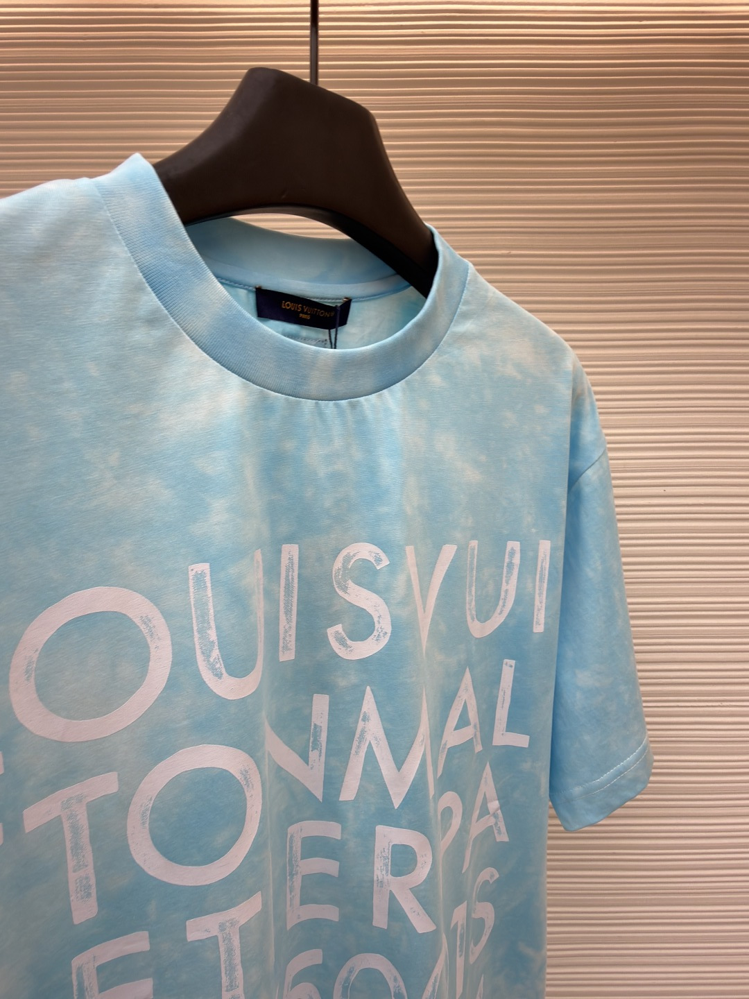 P135 LOUIS VUITTON 云朵扎染圆领短袖
●原版：8500购入开发
●货号：1682621-A10
●面料：平纹针织面料
●工艺：扎染漂白制作
●颜色：蓝白
●版型：合身版型
●克重：约195克
●尺码：XS-S-M-L
●描述：主体采用24S特纺紧密棉打造平纹针织面料，克重185g/㎡。高支数的精梳棉纱通过紧密纺工艺消除了大部分来短毛羽，使得纱线更光滑、强韧。织成的面料结构异常密实、平整且柔软，具有出色的抗起球能力和耐用性，同时保留了纯棉透气亲肤的天然优势。领口则选用32S 1x1罗纹 克重300g，更细的纱支编织出更细腻紧密的螺纹，提供了优于普通罗纹的回弹性与抗变形能力，确保领口历经多次穿脱后仍能保持挺括。通过模仿传统手工艺的现通过捆扎、缝纫或夹板等方式对成衣或面料进行物理防染，然后进行染色。被捆扎的部分染料无法渗入，从而形成独特、不规则且每件都不重复的晕染纹理和图案。通过可控的化学漂洗或酶洗工艺，模拟阳光长期照射后产生的局部褪色效果，形成柔和、自然的色彩层次。这两种工艺共同作用，使每件T恤都拥有独一无二的别致观感，奠定了单品艺术化和手工感的基调。整体走线平直细腻，面料舒适柔软，颜色一致无色差 能与同款搭配营造时尚造型，驾驭各种场合，定制辅料，三标齐全，男女同款！