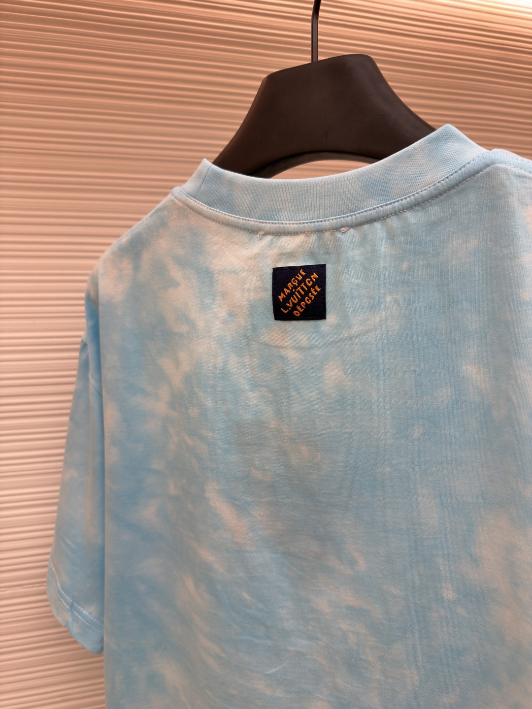 P135 LOUIS VUITTON 云朵扎染圆领短袖
●原版：8500购入开发
●货号：1682621-A10
●面料：平纹针织面料
●工艺：扎染漂白制作
●颜色：蓝白
●版型：合身版型
●克重：约195克
●尺码：XS-S-M-L
●描述：主体采用24S特纺紧密棉打造平纹针织面料，克重185g/㎡。高支数的精梳棉纱通过紧密纺工艺消除了大部分来短毛羽，使得纱线更光滑、强韧。织成的面料结构异常密实、平整且柔软，具有出色的抗起球能力和耐用性，同时保留了纯棉透气亲肤的天然优势。领口则选用32S 1x1罗纹 克重300g，更细的纱支编织出更细腻紧密的螺纹，提供了优于普通罗纹的回弹性与抗变形能力，确保领口历经多次穿脱后仍能保持挺括。通过模仿传统手工艺的现通过捆扎、缝纫或夹板等方式对成衣或面料进行物理防染，然后进行染色。被捆扎的部分染料无法渗入，从而形成独特、不规则且每件都不重复的晕染纹理和图案。通过可控的化学漂洗或酶洗工艺，模拟阳光长期照射后产生的局部褪色效果，形成柔和、自然的色彩层次。这两种工艺共同作用，使每件T恤都拥有独一无二的别致观感，奠定了单品艺术化和手工感的基调。整体走线平直细腻，面料舒适柔软，颜色一致无色差 能与同款搭配营造时尚造型，驾驭各种场合，定制辅料，三标齐全，男女同款！
