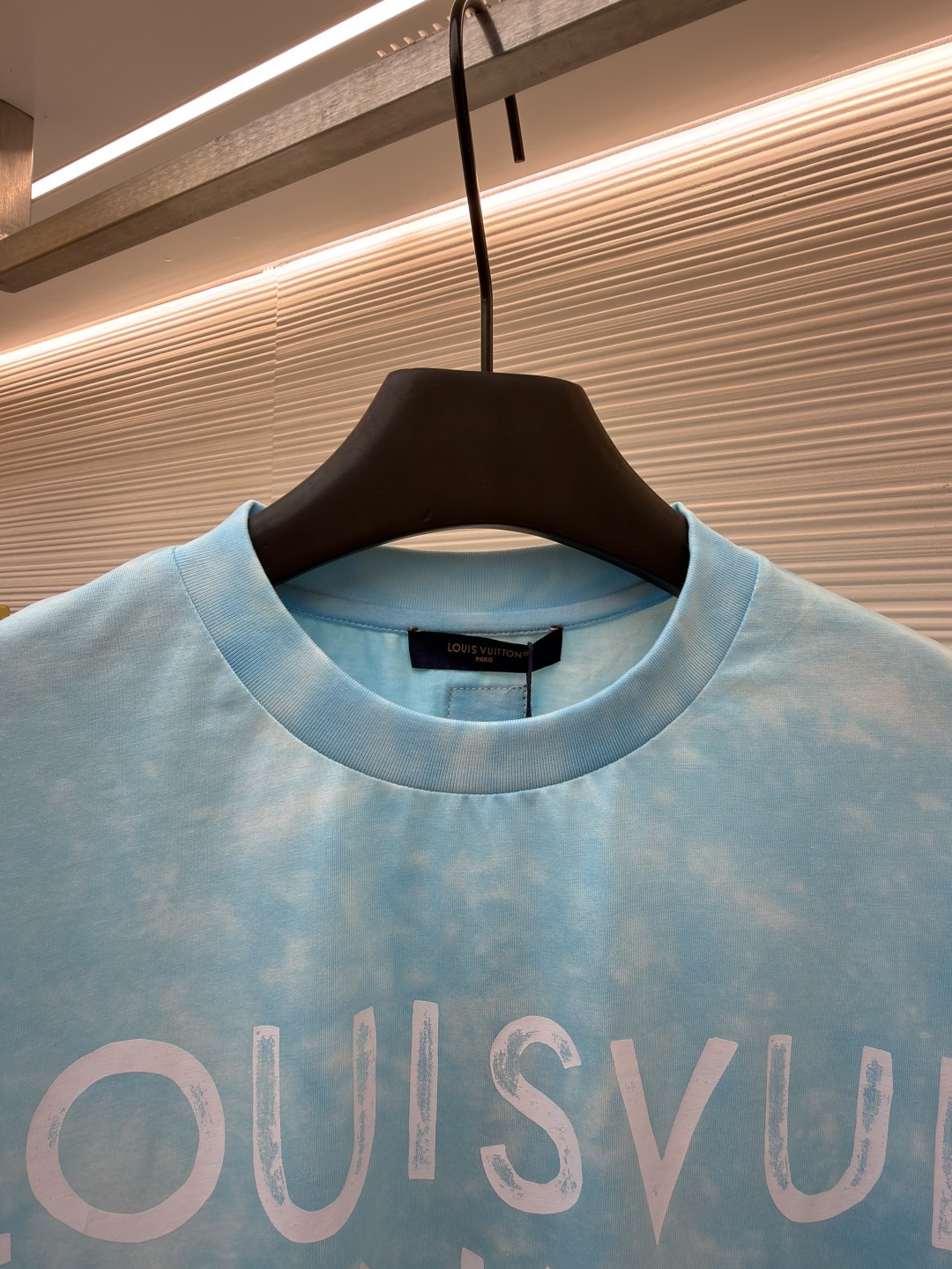 P135 LOUIS VUITTON 云朵扎染圆领短袖
●原版：8500购入开发
●货号：1682621-A10
●面料：平纹针织面料
●工艺：扎染漂白制作
●颜色：蓝白
●版型：合身版型
●克重：约195克
●尺码：XS-S-M-L
●描述：主体采用24S特纺紧密棉打造平纹针织面料，克重185g/㎡。高支数的精梳棉纱通过紧密纺工艺消除了大部分来短毛羽，使得纱线更光滑、强韧。织成的面料结构异常密实、平整且柔软，具有出色的抗起球能力和耐用性，同时保留了纯棉透气亲肤的天然优势。领口则选用32S 1x1罗纹 克重300g，更细的纱支编织出更细腻紧密的螺纹，提供了优于普通罗纹的回弹性与抗变形能力，确保领口历经多次穿脱后仍能保持挺括。通过模仿传统手工艺的现通过捆扎、缝纫或夹板等方式对成衣或面料进行物理防染，然后进行染色。被捆扎的部分染料无法渗入，从而形成独特、不规则且每件都不重复的晕染纹理和图案。通过可控的化学漂洗或酶洗工艺，模拟阳光长期照射后产生的局部褪色效果，形成柔和、自然的色彩层次。这两种工艺共同作用，使每件T恤都拥有独一无二的别致观感，奠定了单品艺术化和手工感的基调。整体走线平直细腻，面料舒适柔软，颜色一致无色差 能与同款搭配营造时尚造型，驾驭各种场合，定制辅料，三标齐全，男女同款！