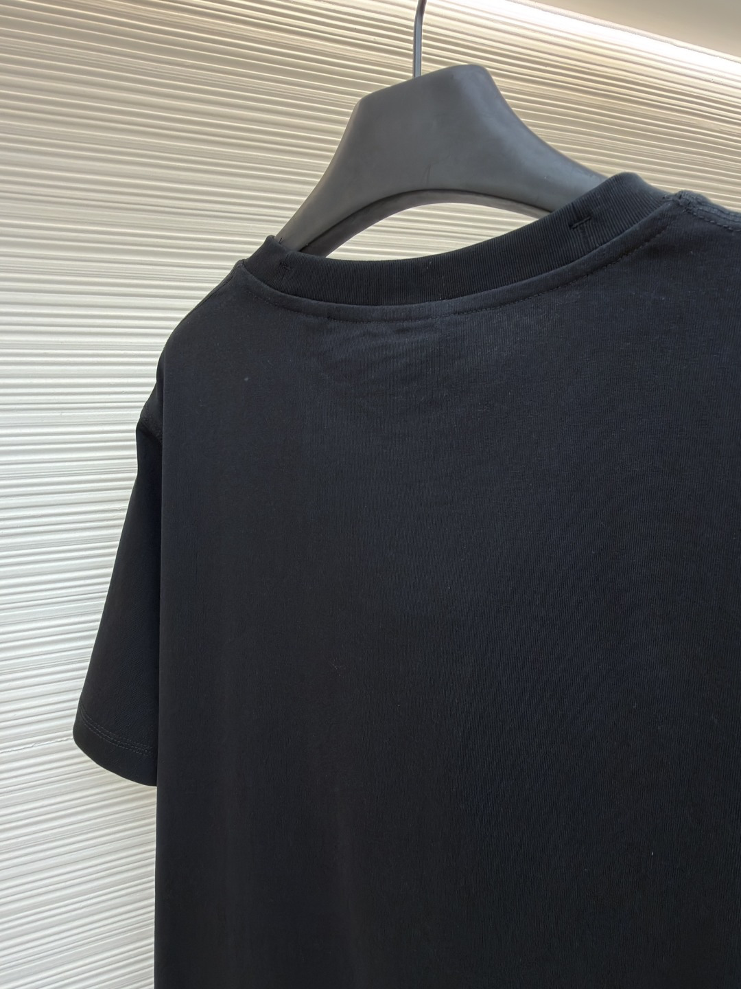 P110 Burberry 经典圆领人字车标格纹标签棉质T恤衫
●原版：3350购入开发
●货号：1682624-X85
●面料：全棉面料
●工艺：人字车标制作
●颜色：黑色
●版型：合身版型
●克重：约265克
●尺码：S-M-L-XL
●描述：此款T恤采用高支精梳棉质面料为基底，经过酵素洗水工艺处理，使面料触感更柔软亲肤，同时增强了成衣的抗皱性与穿着舒适度。领口采用双针包边工艺，搭配加固缝线，耐洗不易变形，贴合颈部曲线的同时保证了持久的穿着寿命。衣身侧面的标志性格纹标签采用精密锁边工艺固定，边缘平整牢固；胸前的品牌标识则以人字车线工艺缝制，针脚细密均匀、线条流畅立体，兼具装饰性与辨识度。整体剪裁为宽松版型，车线工整且线头处理干净，结合专业的预缩水处理，有效降低了穿着洗涤后的缩水率，建议手洗以更好地保护面料与精致工艺。整体走线平直细腻，面料舒适柔软，颜色一致无色差 能与同款搭配营造时尚造型，驾驭各种场合，定制辅料，三标齐全，男女同款！