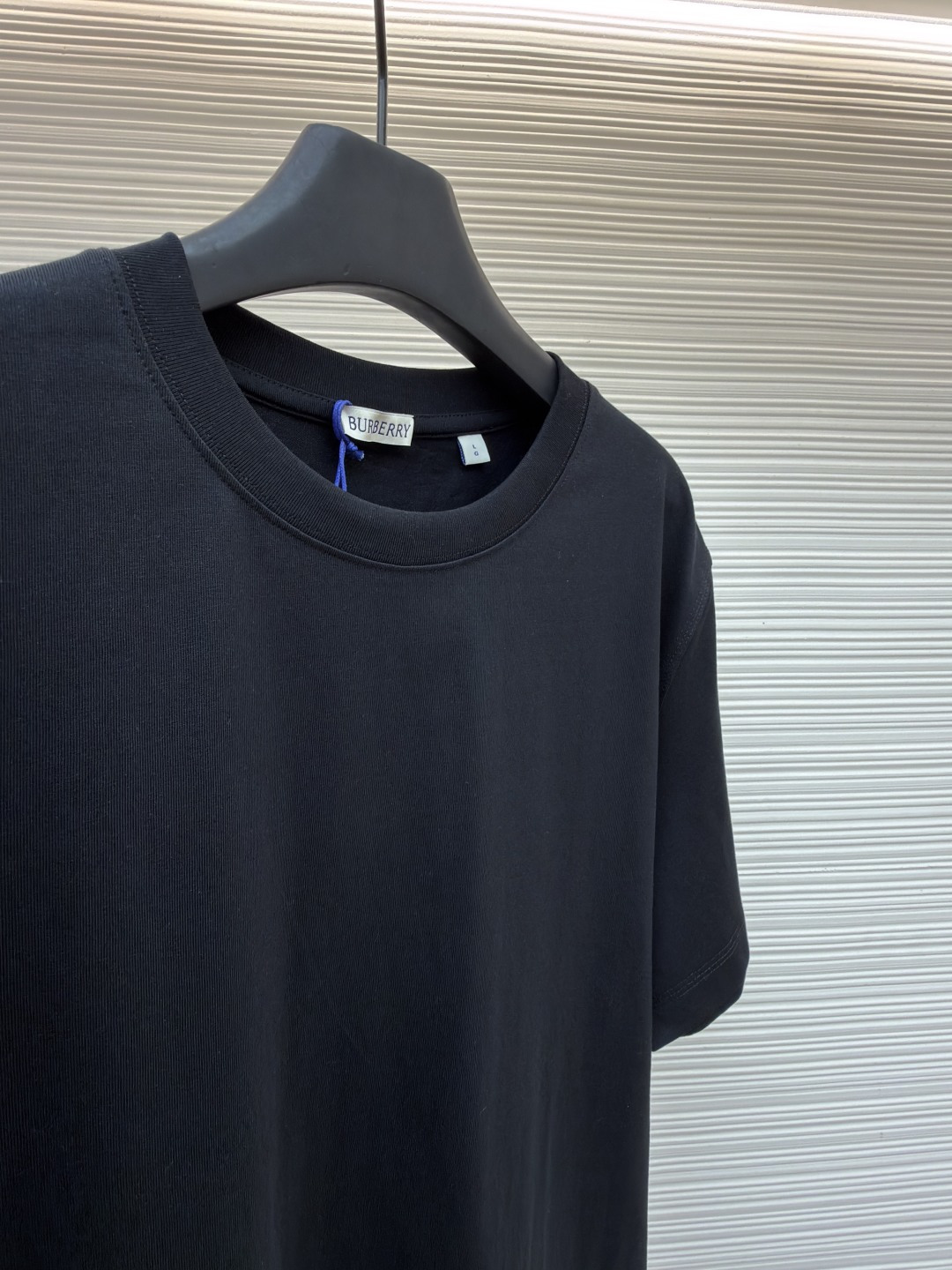 P110 Burberry 经典圆领人字车标格纹标签棉质T恤衫
●原版：3350购入开发
●货号：1682624-X85
●面料：全棉面料
●工艺：人字车标制作
●颜色：黑色
●版型：合身版型
●克重：约265克
●尺码：S-M-L-XL
●描述：此款T恤采用高支精梳棉质面料为基底，经过酵素洗水工艺处理，使面料触感更柔软亲肤，同时增强了成衣的抗皱性与穿着舒适度。领口采用双针包边工艺，搭配加固缝线，耐洗不易变形，贴合颈部曲线的同时保证了持久的穿着寿命。衣身侧面的标志性格纹标签采用精密锁边工艺固定，边缘平整牢固；胸前的品牌标识则以人字车线工艺缝制，针脚细密均匀、线条流畅立体，兼具装饰性与辨识度。整体剪裁为宽松版型，车线工整且线头处理干净，结合专业的预缩水处理，有效降低了穿着洗涤后的缩水率，建议手洗以更好地保护面料与精致工艺。整体走线平直细腻，面料舒适柔软，颜色一致无色差 能与同款搭配营造时尚造型，驾驭各种场合，定制辅料，三标齐全，男女同款！