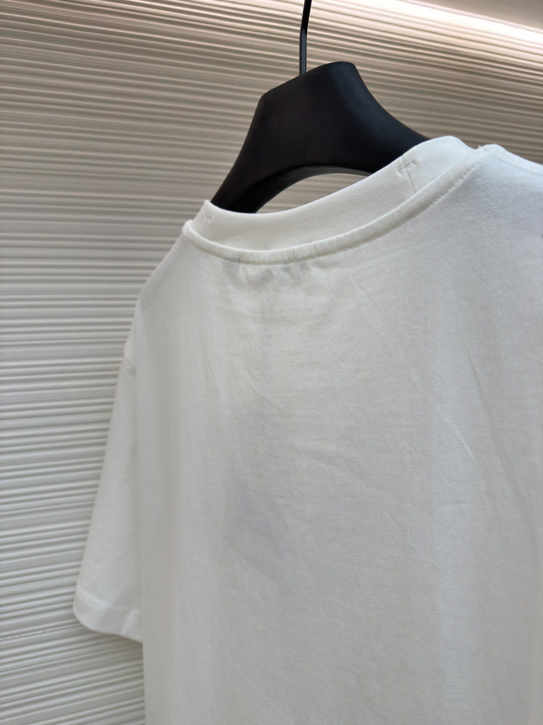 P110 Burberry 经典圆领人字车标格纹标签棉质T恤衫
●原版：3350购入开发
●货号：1682625-X85
●面料：全棉面料
●工艺：人字车标制作
●颜色：白色
●版型：合身版型
●克重：约255克
●尺码：S-M-L-XL
●描述：此款T恤采用高支精梳棉质面料为基底，经过酵素洗水工艺处理，使面料触感更柔软亲肤，同时增强了成衣的抗皱性与穿着舒适度。领口采用双针包边工艺，搭配加固缝线，耐洗不易变形，贴合颈部曲线的同时保证了持久的穿着寿命。衣身侧面的标志性格纹标签采用精密锁边工艺固定，边缘平整牢固；胸前的品牌标识则以人字车线工艺缝制，针脚细密均匀、线条流畅立体，兼具装饰性与辨识度。整体剪裁为宽松版型，车线工整且线头处理干净，结合专业的预缩水处理，有效降低了穿着洗涤后的缩水率，建议手洗以更好地保护面料与精致工艺。整体走线平直细腻，面料舒适柔软，颜色一致无色差 能与同款搭配营造时尚造型，驾驭各种场合，定制辅料，三标齐全，男女同款！