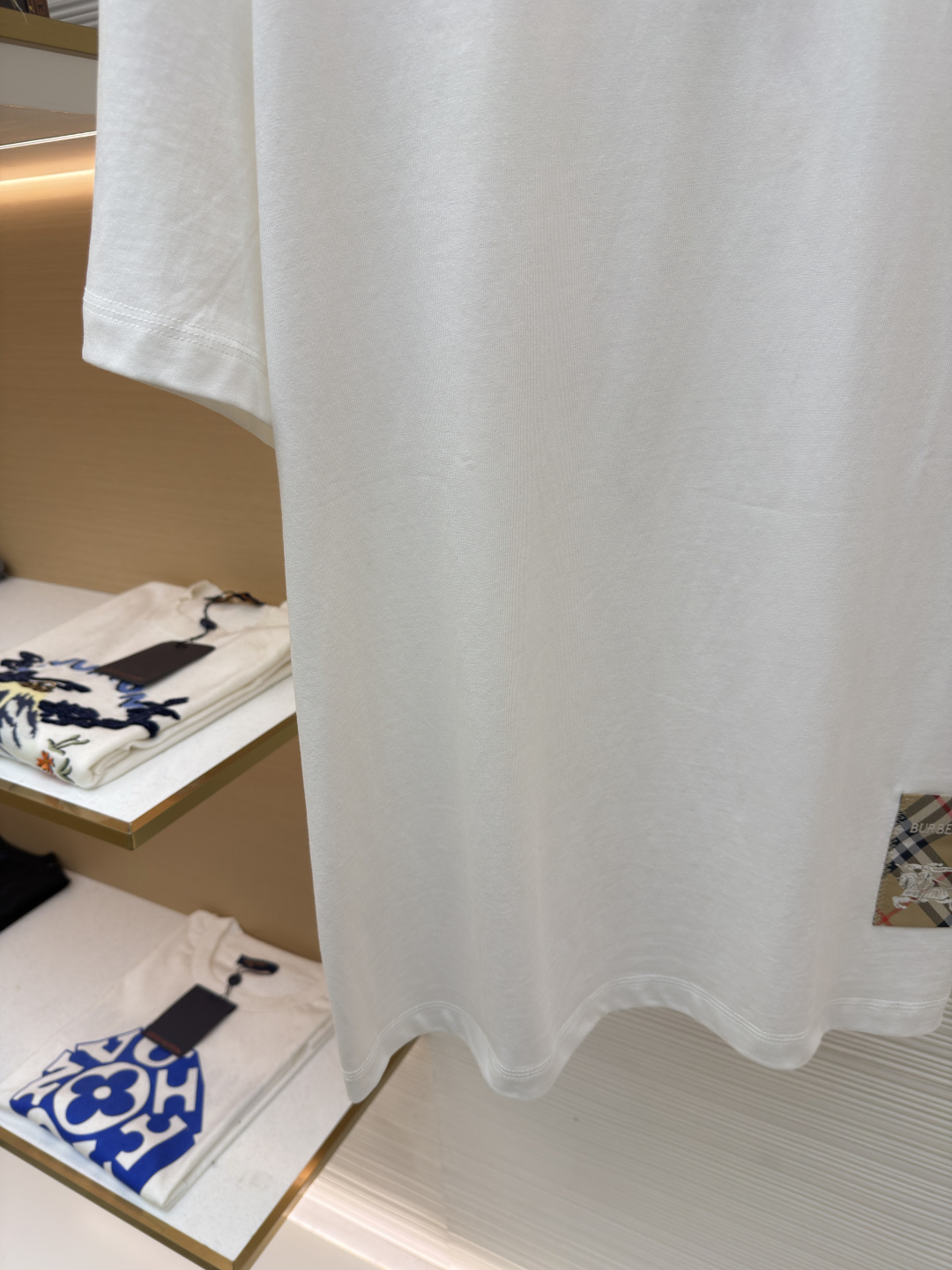 P110 Burberry 经典圆领人字车标格纹标签棉质T恤衫
●原版：3350购入开发
●货号：1682625-X85
●面料：全棉面料
●工艺：人字车标制作
●颜色：白色
●版型：合身版型
●克重：约255克
●尺码：S-M-L-XL
●描述：此款T恤采用高支精梳棉质面料为基底，经过酵素洗水工艺处理，使面料触感更柔软亲肤，同时增强了成衣的抗皱性与穿着舒适度。领口采用双针包边工艺，搭配加固缝线，耐洗不易变形，贴合颈部曲线的同时保证了持久的穿着寿命。衣身侧面的标志性格纹标签采用精密锁边工艺固定，边缘平整牢固；胸前的品牌标识则以人字车线工艺缝制，针脚细密均匀、线条流畅立体，兼具装饰性与辨识度。整体剪裁为宽松版型，车线工整且线头处理干净，结合专业的预缩水处理，有效降低了穿着洗涤后的缩水率，建议手洗以更好地保护面料与精致工艺。整体走线平直细腻，面料舒适柔软，颜色一致无色差 能与同款搭配营造时尚造型，驾驭各种场合，定制辅料，三标齐全，男女同款！