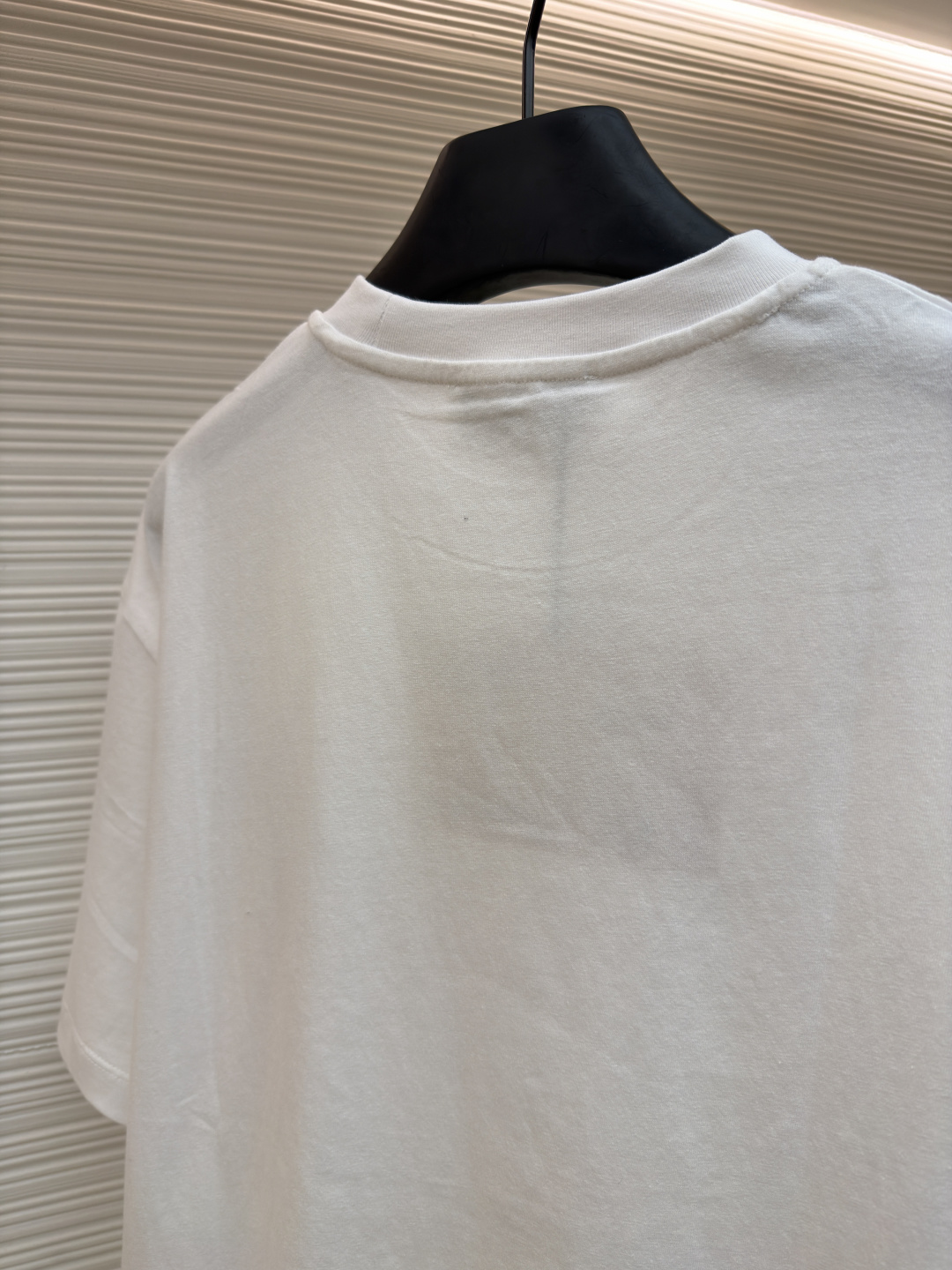 P125 MIU MIU经典字母logo图案短袖
●原版：5350购入开发
●货号：1682626-A00
●面料：精梳棉面料
●工艺：刺绣制作
●颜色：白色
●版型：合身版型
●克重：约220克
●尺码：S-M-L-XL
●描述：这款MIU MIU字母LOGO图案短袖以高支数精梳棉为面料基底，通过酵素洗水工艺处理，使布面触感更柔软顺滑，同时提升了面料的抗皱性与透气性，减少穿着紧绷感。胸前的品牌字母LOGO采用进口刺绣工艺，选用高光泽度的优质绣线，针脚细密均匀、图案立体饱满，兼具细腻质感与品牌辨识度，且经加固处理不易脱线。领口采用双针包边工艺，搭配同色系缝线，耐洗不易变形，贴合颈部曲线的同时保障了穿着舒适度。整体剪裁为宽松落肩版型，车线工整且线头处理干净，结合预缩水处理有效降低了洗涤后的缩水率，建议手洗以更好地保护刺绣细节与面料质感。整体走线平直细腻，面料舒适柔软，颜色一致无色差 能与同款搭配营造时尚造型，驾驭各种场合，定制辅料，三标齐全，男女同款！