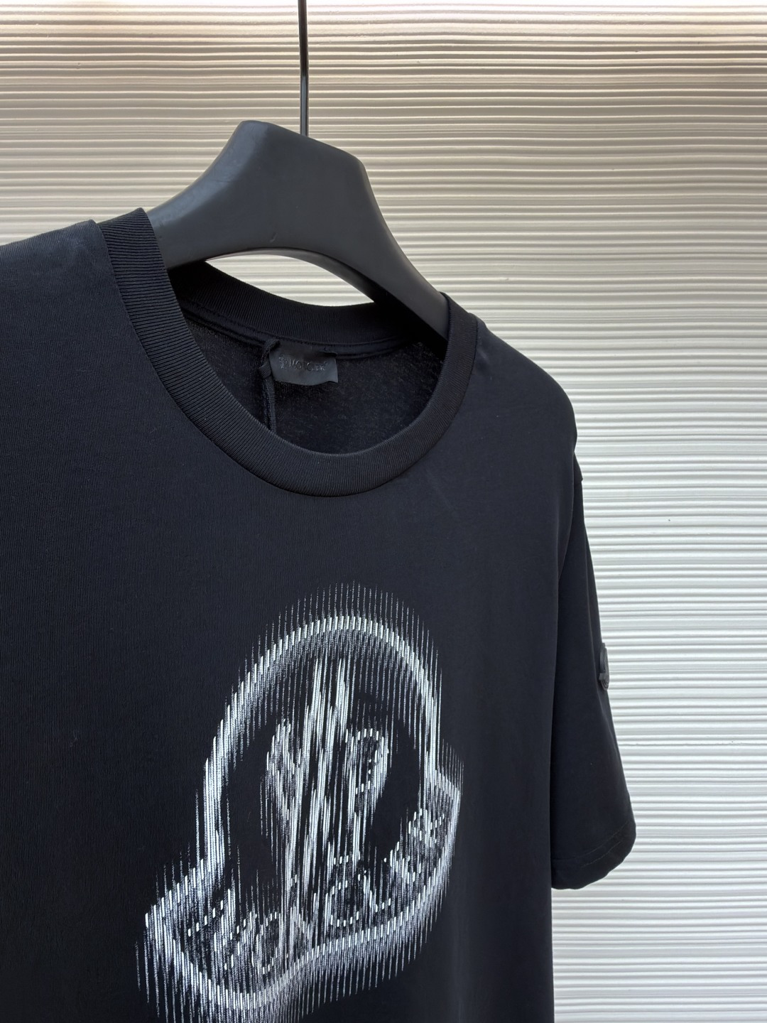 p220 Moncler 字母LOGO标识印花模糊感短袖T恤
●原版：4286购入开发
●面料：精梳棉面料
●工艺：印花制作
●颜色：黑色
●版型：合身版型
●克重：约255克
●尺码：S-M-L-XL
●描述：这款蒙口短袖T恤采用高支精梳棉面料，经过酵素洗工艺处理，触感柔软亲肤且兼具透气性与抗皱性，衣身正面通过数码直喷工艺呈现品牌标志性的模糊感LOGO印花，色彩层次细腻且久洗不易褪色，袖口处嵌入品牌专属橡胶标识牌，兼具辨识度与质感。圆领部分采用同色系罗纹收边，经过预缩水处理，贴合颈部且久穿不易松弛，衣身采用平缝工艺拼接，走线细密均匀，耐洗耐穿不易脱线。整体版型为宽松剪裁，适配多种身形，每一处细节都兼顾了简约设计与穿着舒适度，是打造日常休闲造型的百搭单品。整体走线平直细腻，面料舒适柔软，颜色一致无色差 能与同款搭配营造时尚造型，驾驭各种场合，定制辅料，三标齐全，男女同款！