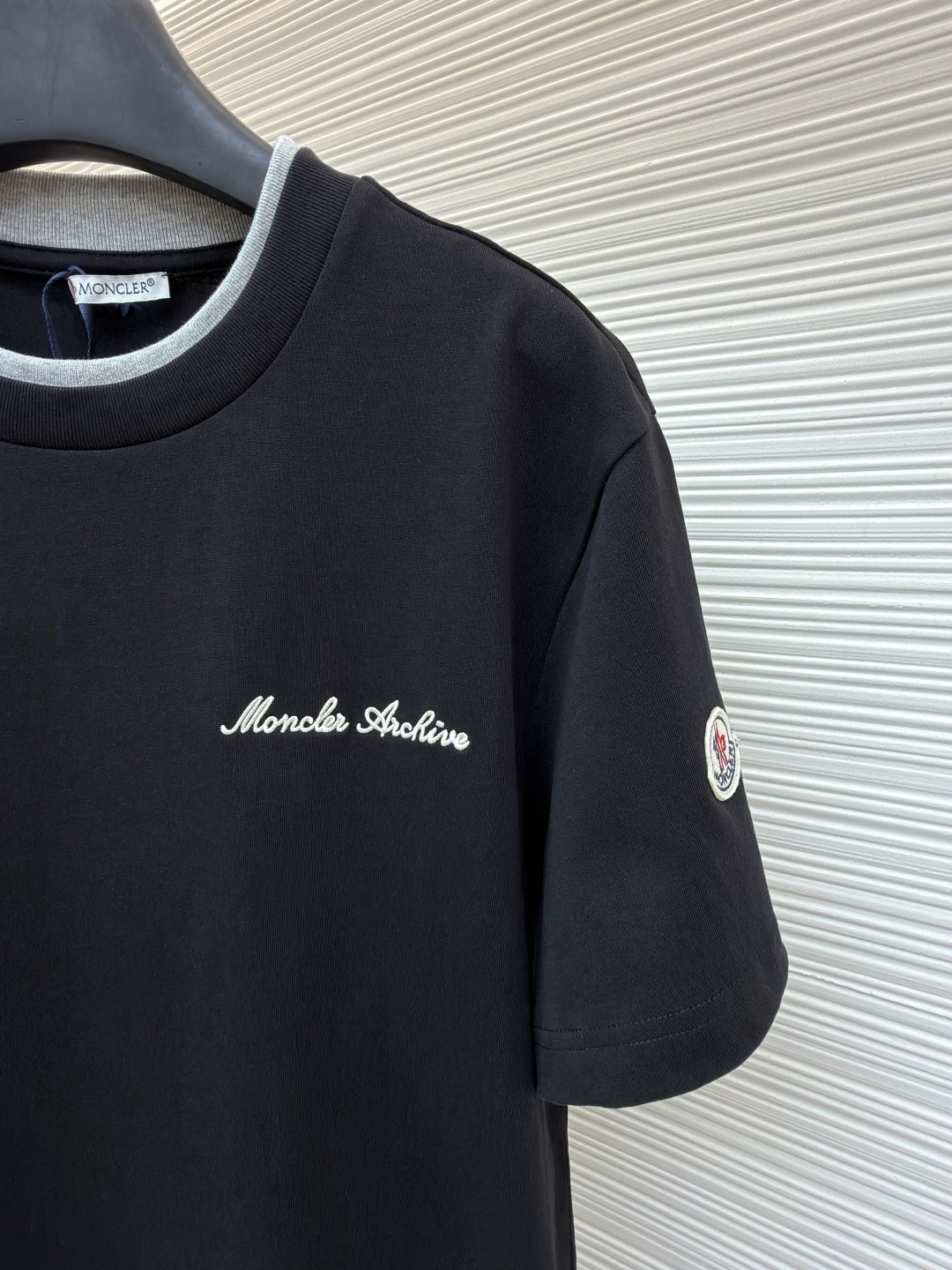 p220 Moncler 刺绣标识假俩件短袖
●原版：3500购入开发
●面料：云柔平纹棉面料
●工艺：刺绣制作
●颜色：黑色
●版型：合身版型
●克重：约320克
●尺码：S-M-L-XL
●描述：定制云柔平纹棉 柔软细腻 舒适贴肤 以极致黑为底 撞色为诗 让色彩拥有呼吸的层次 胸前饰以品牌字样刺绣标识作点缀 与手袖Moncler绣标相得益彰增添品牌辨识度 撞色双领口设计作升华 假两件的错觉美学 让高级感在似与不似之间生出无限想象 领间重构 风格自成采用进口机刺绣工艺 使用先进的计算机控制系统和精密的机械部件 实现Moncler标识刺绣作业  精度高 线条流畅而细腻。画样缝纫机工艺  通过电脑软件输入所需的图案 高精度的定位系统 确保图案在布料上的准确位置 具备自动缝纫功能 能够自动完成缝纫过程，面料都经过浇洗 手感质感更佳 不易变形 不易缩水 不易褪色 保持长久的美观。整体走线平直细腻，面料舒适柔软，颜色一致无色差 能与同款搭配营造时尚造型，驾驭各种场合，定制辅料，三标齐全，男女同款！