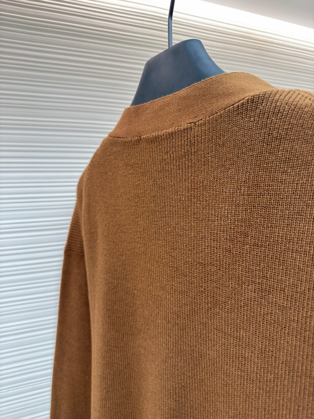 p400 LOUIS VUITTON 字母徽章标识针织V领开衫毛衣
●面料：羊毛面料
●工艺：针织制作
●颜色：棕色
●版型：合身版型
●克重：约535克
●尺码：S-M-L-XL
●描述：这款焦糖棕V领开衫采用高支数羊毛混纺针织面料，经双股线精密织造，兼具保暖性与透气性，表面纹理细腻且抗起球性能优异，色牢度达4.5级以上，久穿不易褪色变形。V领采用包边嵌条工艺，领口挺括不易变形；门襟选用四颗哑光质感的定制金属纽扣，扣眼采用加固锁边工艺，耐用性更强。衣身两侧嵌缝立体贴袋，袋口做双针明线加固，兼具实用性与美观度；袖口及下摆采用罗纹收边，弹力适中贴合身形且不易松弛。成衣经过整烫定型、线头修剪等多道后整理工序，针脚均匀细密，走线流畅无跳线，整体版型宽松有度，日常穿搭舒适随性，适配多种风格场景。整体走线平直细腻，面料舒适柔软，颜色一致无色差 能与同款搭配营造时尚造型，驾驭各种场合，定制辅料，三标齐全，男女同款！