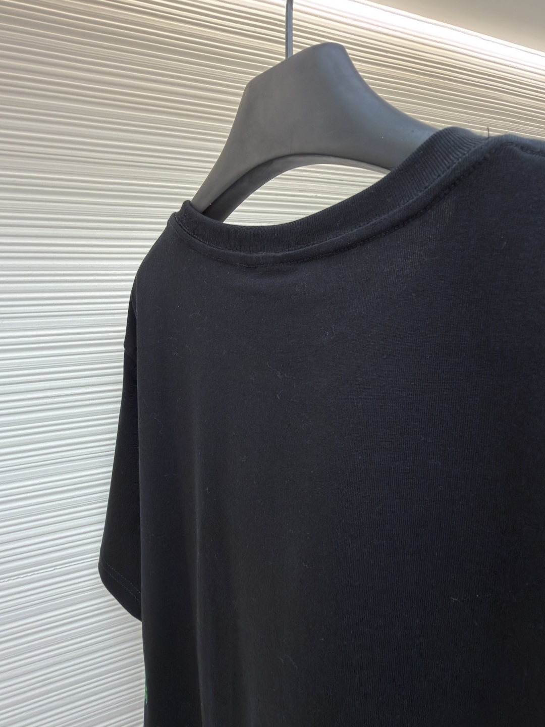 p225 Dior 棉质宽松圆领四叶草刺绣图案T恤
●原版：12000购入开发
●面料：精梳棉面料
●工艺：刺绣制作
●颜色：黑色
●版型：合身版型
●克重：约345克
●尺码：S-M-L-XL
●描述：这款黑色短袖T恤采用高支双股精梳棉混纺面料，经预缩与抗起球处理，触感柔软亲肤，透气吸汗且不易变形起球，色牢度达4级以上，久洗不易褪色发白。领口采用高弹力罗纹搭配三本针包边工艺，反复穿着不易松弛卷边；衣身侧缝采用双针埋夹工艺，走线平整牢固，减少皮肤摩擦感。衣身分布的绿色三叶草图案采用精密刺绣工艺，针脚细密均匀，图案立体饱满且不易脱线；右下角品牌标识采用精细胶印工艺，附着力强不易脱落。成衣经过验针、整烫、去污等多道质检工序，版型宽松有度，适配日常休闲、约会出游等多种场景，兼具精致细节与实穿性。整体走线平直细腻，面料舒适柔软，颜色一致无色差 能与同款搭配营造时尚造型，驾驭各种场合，定制辅料，三标齐全，男女同款！