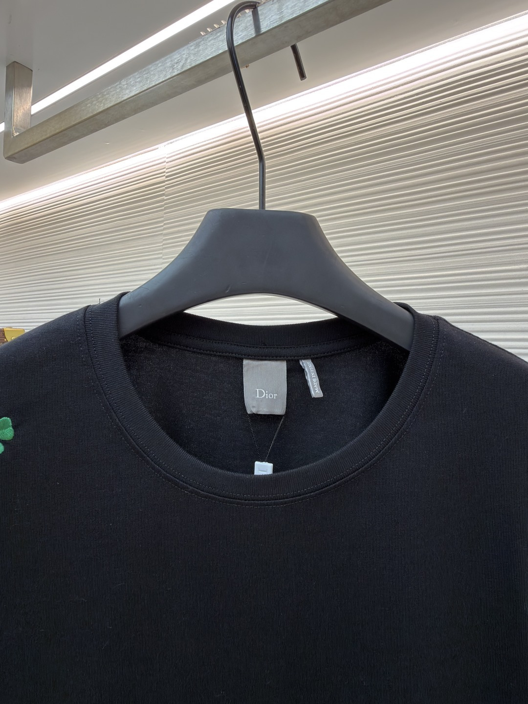 p225 Dior 棉质宽松圆领四叶草刺绣图案T恤
●原版：12000购入开发
●面料：精梳棉面料
●工艺：刺绣制作
●颜色：黑色
●版型：合身版型
●克重：约345克
●尺码：S-M-L-XL
●描述：这款黑色短袖T恤采用高支双股精梳棉混纺面料，经预缩与抗起球处理，触感柔软亲肤，透气吸汗且不易变形起球，色牢度达4级以上，久洗不易褪色发白。领口采用高弹力罗纹搭配三本针包边工艺，反复穿着不易松弛卷边；衣身侧缝采用双针埋夹工艺，走线平整牢固，减少皮肤摩擦感。衣身分布的绿色三叶草图案采用精密刺绣工艺，针脚细密均匀，图案立体饱满且不易脱线；右下角品牌标识采用精细胶印工艺，附着力强不易脱落。成衣经过验针、整烫、去污等多道质检工序，版型宽松有度，适配日常休闲、约会出游等多种场景，兼具精致细节与实穿性。整体走线平直细腻，面料舒适柔软，颜色一致无色差 能与同款搭配营造时尚造型，驾驭各种场合，定制辅料，三标齐全，男女同款！