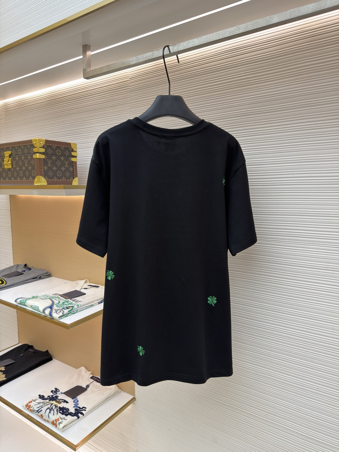 p225 Dior 棉质宽松圆领四叶草刺绣图案T恤
●原版：12000购入开发
●面料：精梳棉面料
●工艺：刺绣制作
●颜色：黑色
●版型：合身版型
●克重：约345克
●尺码：S-M-L-XL
●描述：这款黑色短袖T恤采用高支双股精梳棉混纺面料，经预缩与抗起球处理，触感柔软亲肤，透气吸汗且不易变形起球，色牢度达4级以上，久洗不易褪色发白。领口采用高弹力罗纹搭配三本针包边工艺，反复穿着不易松弛卷边；衣身侧缝采用双针埋夹工艺，走线平整牢固，减少皮肤摩擦感。衣身分布的绿色三叶草图案采用精密刺绣工艺，针脚细密均匀，图案立体饱满且不易脱线；右下角品牌标识采用精细胶印工艺，附着力强不易脱落。成衣经过验针、整烫、去污等多道质检工序，版型宽松有度，适配日常休闲、约会出游等多种场景，兼具精致细节与实穿性。整体走线平直细腻，面料舒适柔软，颜色一致无色差 能与同款搭配营造时尚造型，驾驭各种场合，定制辅料，三标齐全，男女同款！