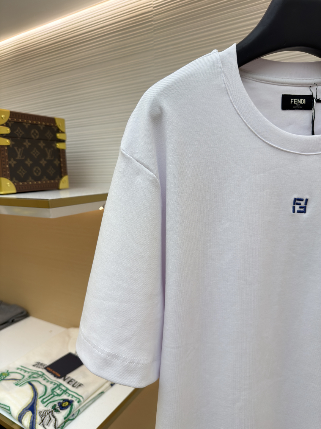 p230 Fendi 米粒刺绣圆领短袖
●原版：5800购入开发
●面料：平纹针织面料
●工艺：刺绣制作
●颜色：白色
●版型：合身版型
●克重：约385克
●尺码：XS-S-M-L
●描述：采用24支双面棉质针织面料，克重为270g/㎡。24支属于中支数，赋予面料适中的厚度和良好的耐用性。双面结构面料正反面质感一致，质地均匀、平整且具有一定的弹性和挺括度。克重属于重磅级别，这确保具有优异的挺括感、垂坠感和抗皱性，成衣廓形饱满不易软塌。指使用平针针法通过高密度、平行排列的直线针脚来填充图案区域。其作用是形成光滑、平整、饱满的绣面，色彩均匀，覆盖力强。通过增加绣线层数在刺绣时使用较粗的绣线实现，使图案明显凸出于面料表面，形成触手可及的浮雕感。整体走线平直细腻，面料舒适柔软，颜色一致无色差 能与同款搭配营造时尚造型，驾驭各种场合，定制辅料，三标齐全，男女同款！