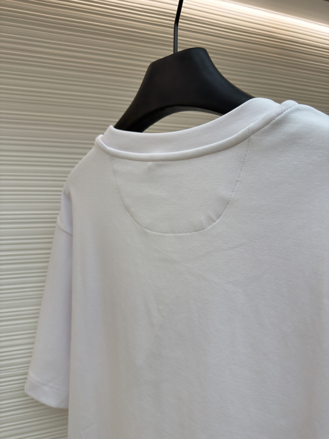 p230 Fendi 米粒刺绣圆领短袖
●原版：5800购入开发
●面料：平纹针织面料
●工艺：刺绣制作
●颜色：白色
●版型：合身版型
●克重：约385克
●尺码：XS-S-M-L
●描述：采用24支双面棉质针织面料，克重为270g/㎡。24支属于中支数，赋予面料适中的厚度和良好的耐用性。双面结构面料正反面质感一致，质地均匀、平整且具有一定的弹性和挺括度。克重属于重磅级别，这确保具有优异的挺括感、垂坠感和抗皱性，成衣廓形饱满不易软塌。指使用平针针法通过高密度、平行排列的直线针脚来填充图案区域。其作用是形成光滑、平整、饱满的绣面，色彩均匀，覆盖力强。通过增加绣线层数在刺绣时使用较粗的绣线实现，使图案明显凸出于面料表面，形成触手可及的浮雕感。整体走线平直细腻，面料舒适柔软，颜色一致无色差 能与同款搭配营造时尚造型，驾驭各种场合，定制辅料，三标齐全，男女同款！