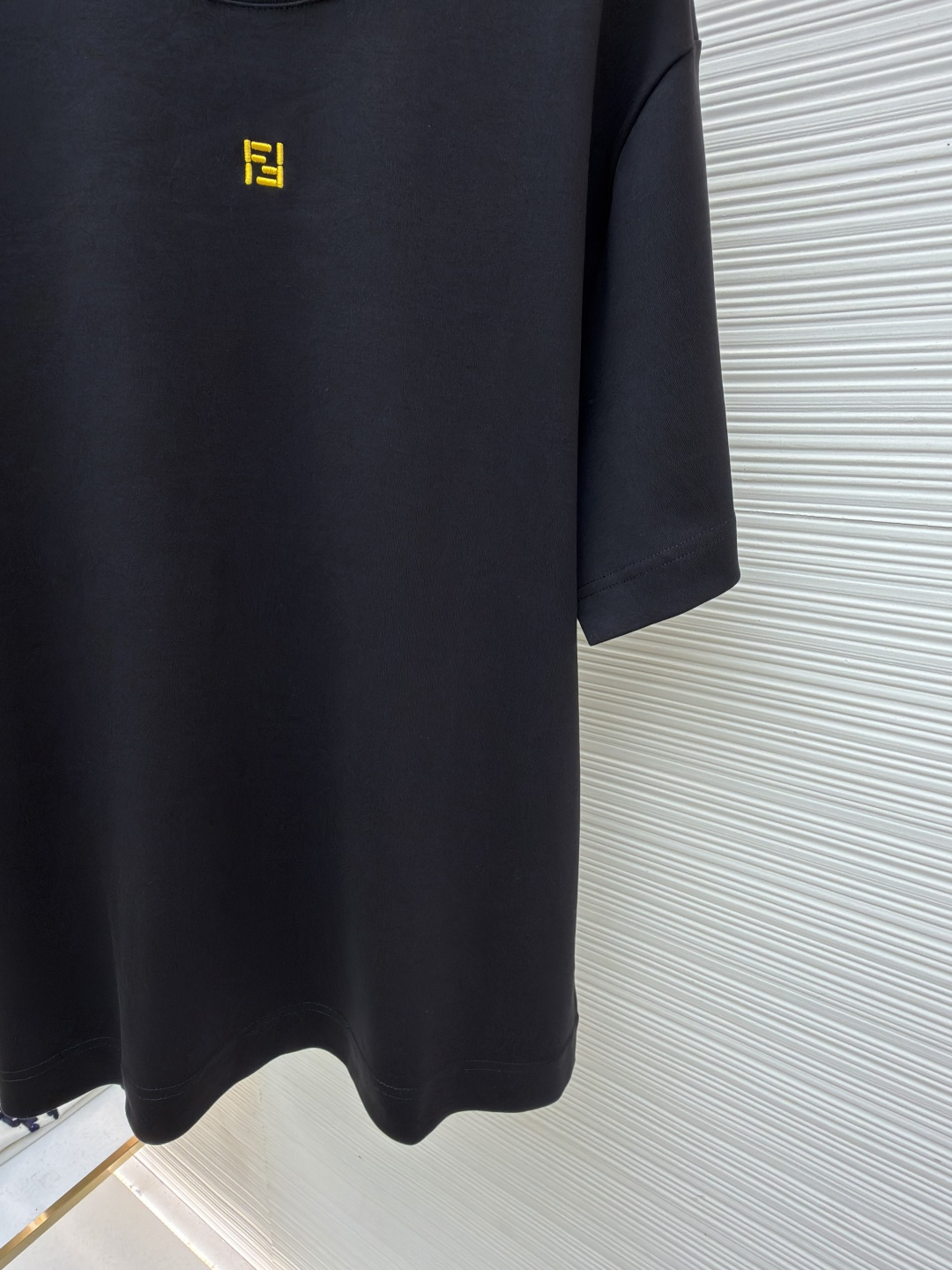 p230 Fendi 米粒刺绣圆领短袖
●原版：5800购入开发
●面料：平纹针织面料
●工艺：刺绣制作
●颜色：黑色
●版型：合身版型
●克重：约380克
●尺码：XS-S-M-L
●描述：采用24支双面棉质针织面料，克重为270g/㎡。24支属于中支数，赋予面料适中的厚度和良好的耐用性。双面结构面料正反面质感一致，质地均匀、平整且具有一定的弹性和挺括度。克重属于重磅级别，这确保具有优异的挺括感、垂坠感和抗皱性，成衣廓形饱满不易软塌。指使用平针针法通过高密度、平行排列的直线针脚来填充图案区域。其作用是形成光滑、平整、饱满的绣面，色彩均匀，覆盖力强。通过增加绣线层数在刺绣时使用较粗的绣线实现，使图案明显凸出于面料表面，形成触手可及的浮雕感。整体走线平直细腻，面料舒适柔软，颜色一致无色差 能与同款搭配营造时尚造型，驾驭各种场合，定制辅料，三标齐全，男女同款！