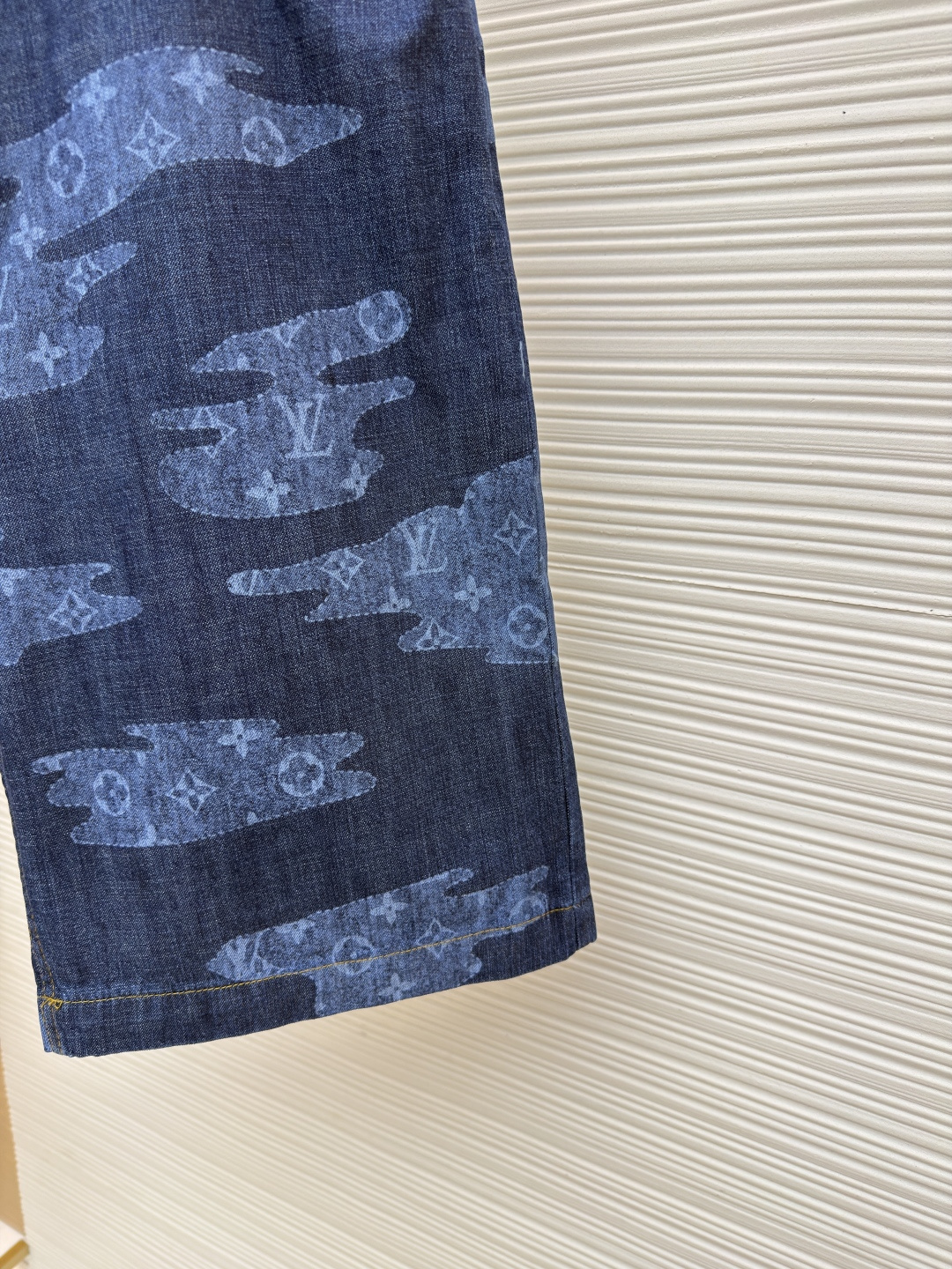 p355 LOUIS VUITTON 青年布短裤
●原版：12000购入开发
●面料：莱赛尔纤维牛仔布面料
●工艺：定位裁床制作
●颜色：蓝色
●版型：合身版型
●克重：约265克
●尺码：S-M-L-XL
●描述：这款路易威登青年布短裤采用重磅青年布面料，经成衣洗褪工艺处理，形成自然的做旧纹理与柔软触感，色牢度达4级以上，久洗不易褪色变形；面料兼具牛仔的挺括感与棉布的透气性，适合夏季穿着。短裤采用定位裁床工艺，精准对齐迷彩图案纹理，确保左右裤身花纹对称协调；腰头搭配定制工字扣与隐形袢带，提升穿着稳固性；侧缝与裆部采用双线加固缝制，针脚细密均匀，增强耐穿性；裤脚做自然毛边处理，保留复古质感。成衣经过整烫定型、线头修剪等多道后整理工序，版型宽松有度，适配日常休闲、户外出行等场景，兼具品牌辨识度与实穿性。整体走线平直细腻，面料舒适柔软，颜色一致无色差 能与同款搭配营造时尚造型，驾驭各种场合，定制辅料，三标齐全，男女同款！