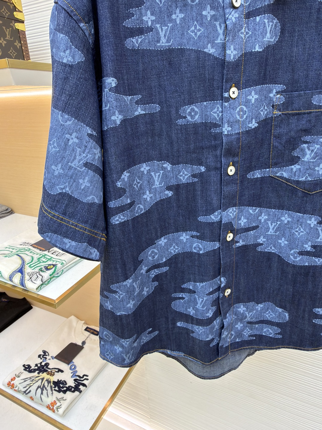 p365 LOUIS VUITTON  短袖青年布衬衫
●原版：13900购入开发
●面料：莱赛尔纤维牛仔布面料
●工艺：定位裁床制作
●颜色：蓝色
●版型：合身版型
●克重：约385克
●尺码：S-M-L-XL
●描述：这款路易威登短袖青年布衬衫采用重磅青年布面料，经成衣洗褪工艺处理，形成自然做旧纹理与柔软触感，色牢度达4级以上，久洗不易褪色变形，面料兼具牛仔挺括感与棉布透气性，适配多季节穿着。衬衫采用定位裁床工艺，精准对齐迷彩老花图案，确保左右衣身花纹对称协调；领部采用加固包边工艺，搭配定制天然贝壳扣，提升穿着稳固性与质感；侧缝与肩线采用双线缝制，针脚细密均匀，增强耐穿性；袖口做平缝锁边处理，保留利落版型。成衣经过整烫定型、线头修剪等多道后整理工序，版型宽松有度，适配日常通勤、休闲出游等场景，兼具品牌辨识度与实穿性。整体走线平直细腻，面料舒适柔软，颜色一致无色差 能与同款搭配营造时尚造型，驾驭各种场合，定制辅料，三标齐全，男女同款！