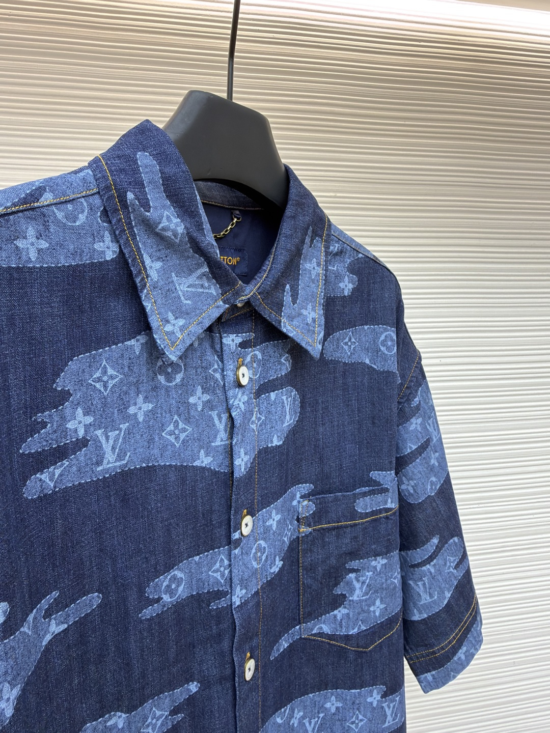 p365 LOUIS VUITTON  短袖青年布衬衫
●原版：13900购入开发
●面料：莱赛尔纤维牛仔布面料
●工艺：定位裁床制作
●颜色：蓝色
●版型：合身版型
●克重：约385克
●尺码：S-M-L-XL
●描述：这款路易威登短袖青年布衬衫采用重磅青年布面料，经成衣洗褪工艺处理，形成自然做旧纹理与柔软触感，色牢度达4级以上，久洗不易褪色变形，面料兼具牛仔挺括感与棉布透气性，适配多季节穿着。衬衫采用定位裁床工艺，精准对齐迷彩老花图案，确保左右衣身花纹对称协调；领部采用加固包边工艺，搭配定制天然贝壳扣，提升穿着稳固性与质感；侧缝与肩线采用双线缝制，针脚细密均匀，增强耐穿性；袖口做平缝锁边处理，保留利落版型。成衣经过整烫定型、线头修剪等多道后整理工序，版型宽松有度，适配日常通勤、休闲出游等场景，兼具品牌辨识度与实穿性。整体走线平直细腻，面料舒适柔软，颜色一致无色差 能与同款搭配营造时尚造型，驾驭各种场合，定制辅料，三标齐全，男女同款！