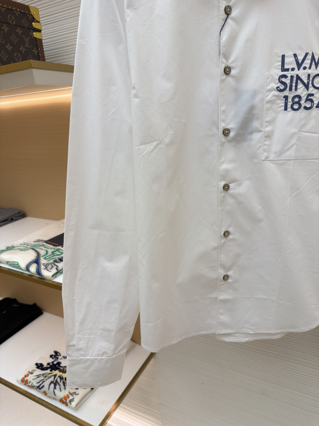 p365 LOUIS VUITTON 缎纹绣衬衫
●原版：10400购入开发
●面料：全棉面料
●工艺：刺绣制作
●颜色：白色
●版型：合身版型
●克重：约290克
●尺码：XS-S-M-L
●描述：本款由棉质府绸剪裁的挺括衬衫，因2026年春夏秀场的IVLegacy标识而更显精致。灵感源自路易威登个性化行李箱的历史，胸前口袋处印有模拟手绘效果的对比色LV.M.字母。本款多功能单品可搭配正式与日常造型。整体走线平直细腻，面料舒适柔软，颜色一致无色差 能与同款搭配营造时尚造型，驾驭各种场合，定制辅料，三标齐全，男女同款！