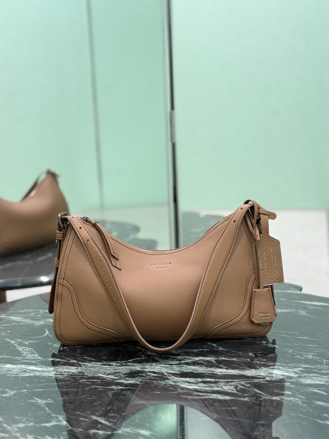 NO:688611,New Aimee Shoulder Bag This new interpretation of the iconic Aimée bag celebrates the heritage of the P family with a design that recalls the theme of travel. The unique hobo silhouette adds a new element, as the leather is richly textured and exhibits fine, irregular textures for a natural and sophisticated effect. Reinforced corners inspired by travel bags highlight the craftsmanship and timeless character of this style. Removable keychain/iron stamped hangtag. Dimensions: L 36 x H 20 x Bottom 11 cm  Style number 1BC280, Prada [top original order], prada, travel bags, shoulder bags19860909新款Aimee 单肩包 这款标志性Aimée包袋的全新诠释以令人想起旅行主题的设计,颂扬了P家的传统.独特的hobo版型增添了新的元素,因为皮革纹理丰富,呈现出精细、不规则的纹理,呈现出自然而精致的效果.灵感源自旅行包的加固边角彰显了工匠精神和这一风格的永恒特征.可拆卸钥匙圈/烫字吊牌. 尺寸长36x高20x底11cm 款号1BC280,普拉达【顶级原单】,prada,travel bags,shoulder bags,Bag