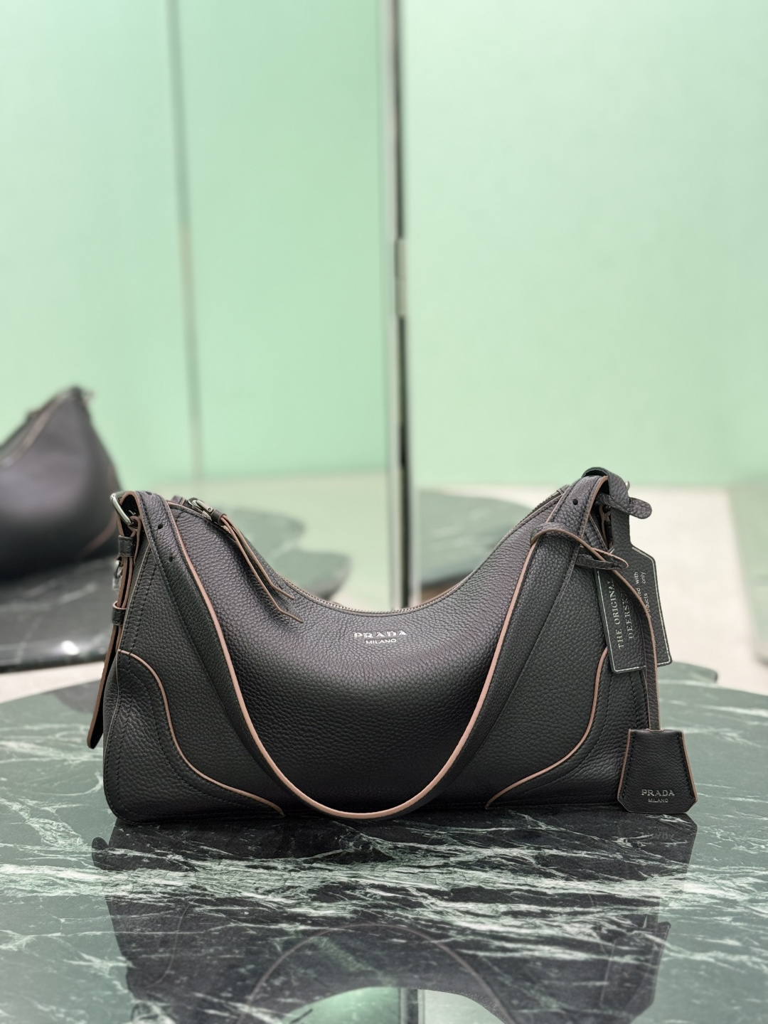 NO:688636,New Aimee Shoulder Bag This new interpretation of the iconic Aimée bag celebrates the heritage of the P family with a design that recalls the theme of travel. The unique hobo silhouette adds a new element, as the leather is richly textured and exhibits fine, irregular textures for a natural and sophisticated effect. Reinforced corners inspired by travel bags highlight the craftsmanship and timeless character of this style. Removable keychain/iron stamped hangtag. Dimensions: L 36 x H 20 x Bottom 11 cm  Style number 1BC280, Prada [top original order], prada, travel bags, shoulder bags19860909新款Aimee 单肩包 这款标志性Aimée包袋的全新诠释以令人想起旅行主题的设计,颂扬了P家的传统.独特的hobo版型增添了新的元素,因为皮革纹理丰富,呈现出精细、不规则的纹理,呈现出自然而精致的效果.灵感源自旅行包的加固边角彰显了工匠精神和这一风格的永恒特征.可拆卸钥匙圈/烫字吊牌. 尺寸长36x高20x底11cm 款号1BC280,普拉达【顶级原单】,prada,travel bags,shoulder bags,Bag