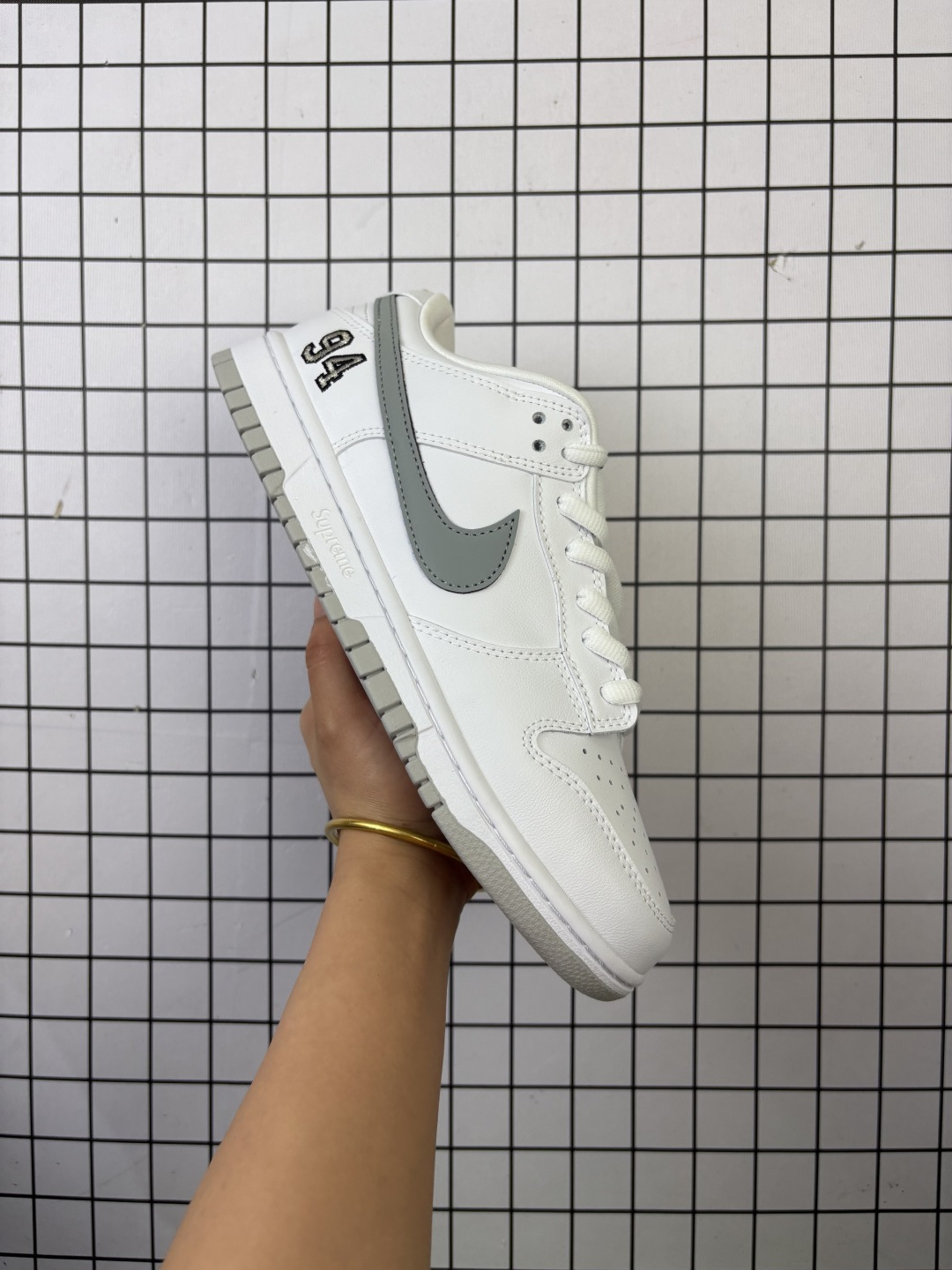 💰220 头层带半码 Supreme x Nike Dunk SB Low Pro OG Sup x 耐克 SB 低帮 联名白灰 鞋身以白色作为主色调，搭配白色框架覆盖层，使鞋款十分百搭，鞋舌绣标上以Nike Swoosh Logo呈现，鞋身两侧的Swoosh Logo采用灰色点缀，后跟饰片采辅以白色皮革妆点，鞋舌是网眼布材料，增强了透气性，整体十分百搭。后跟Nike字样以白色刺绣妆点，后跟绣有雕刻94数字，中底以及鞋垫内侧均带有Supreme字样，彰显联名身份，随鞋还附赠了红色Supreme吊牌；最后以白色中底搭配同色橡胶外底完善整体设计收尾。 货号：HQ8487-100 尺码：36 36.5 37.5 38 38.5 39 40 40.5 41 42 42.5 43 44 44.5 45 46 47.5 编码757