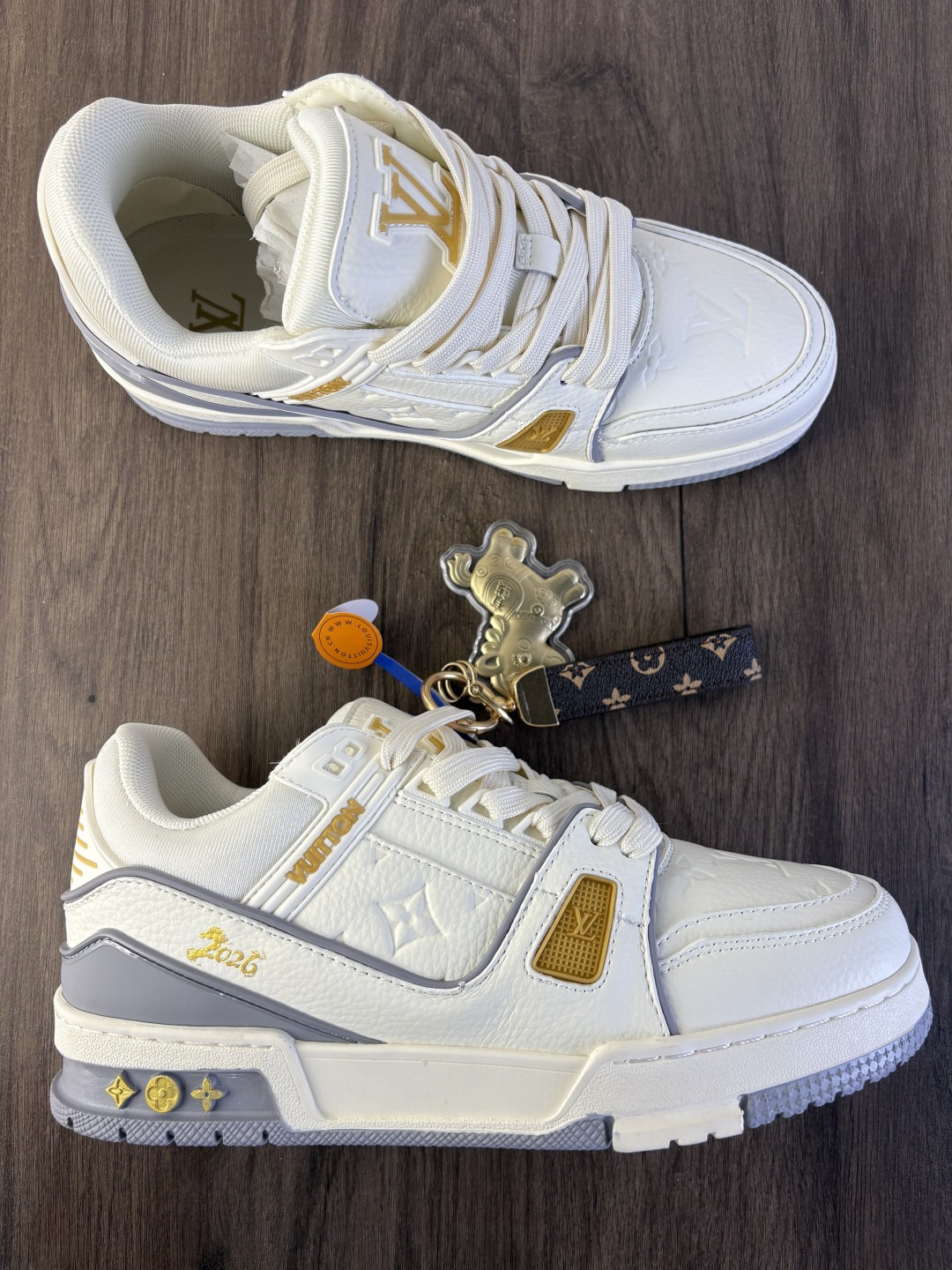 LV TRAINER迷彩马纹(中国红限定礼盒版本-钥匙扣丢失扣10元) 26年限定中国红礼盒及全套包装说明书防尘布袋物件,完美楦型,独家开模定制! trainer这个系列是路易威登融合街头潮流与高级时装的标志性之作.在材料选用上,鞋面采用Monogram印花与Monogram压纹粒面牛皮革的搭配,呈现出独特的复古韵味.荔枝纹粒面头层牛革鞋面,触感细腻且富有韧性,自带自然的皮革纹理,彰显高级质感,为鞋子增添了丰富的层次感.鞋垫采用原版超软乳胶材质,新鞋零磨合不磨脚,软乎乎的皮质包裹感超棒,鞋底则采用橡胶材质,刻有经典的Monogram花卉纹路,不仅防滑,还带走缓震效果还极具设计感.做工方面,TRAINER系列板鞋展现了精湛的工艺水准.鞋头采用圆润设计,原版空胶工艺搭配包边工艺,不仅美观,还能有效防踢蹭.鞋舌、侧面和后部饰有LV字母,侧面还有Vuitton标识,均做工精细,彰显品牌身份.鞋身走线工整均匀,看不到任何多余的线头,皮革的拼接处也处理得极为细腻,体现了我们对细节的极致追求.百搭属性直接封神!配牛仔裤是复古街头风,搭西装裤秒变松弛通勤感,甚至配半身裙都甜妹感拉满,堪称"衣柜万能钥匙".这双集颜值、质感、实穿性于一体的奢牌板鞋! 货号:2A8DM21VL IZE:36 37 38 39 40 41 42 43 44 45(不带半) 编码577