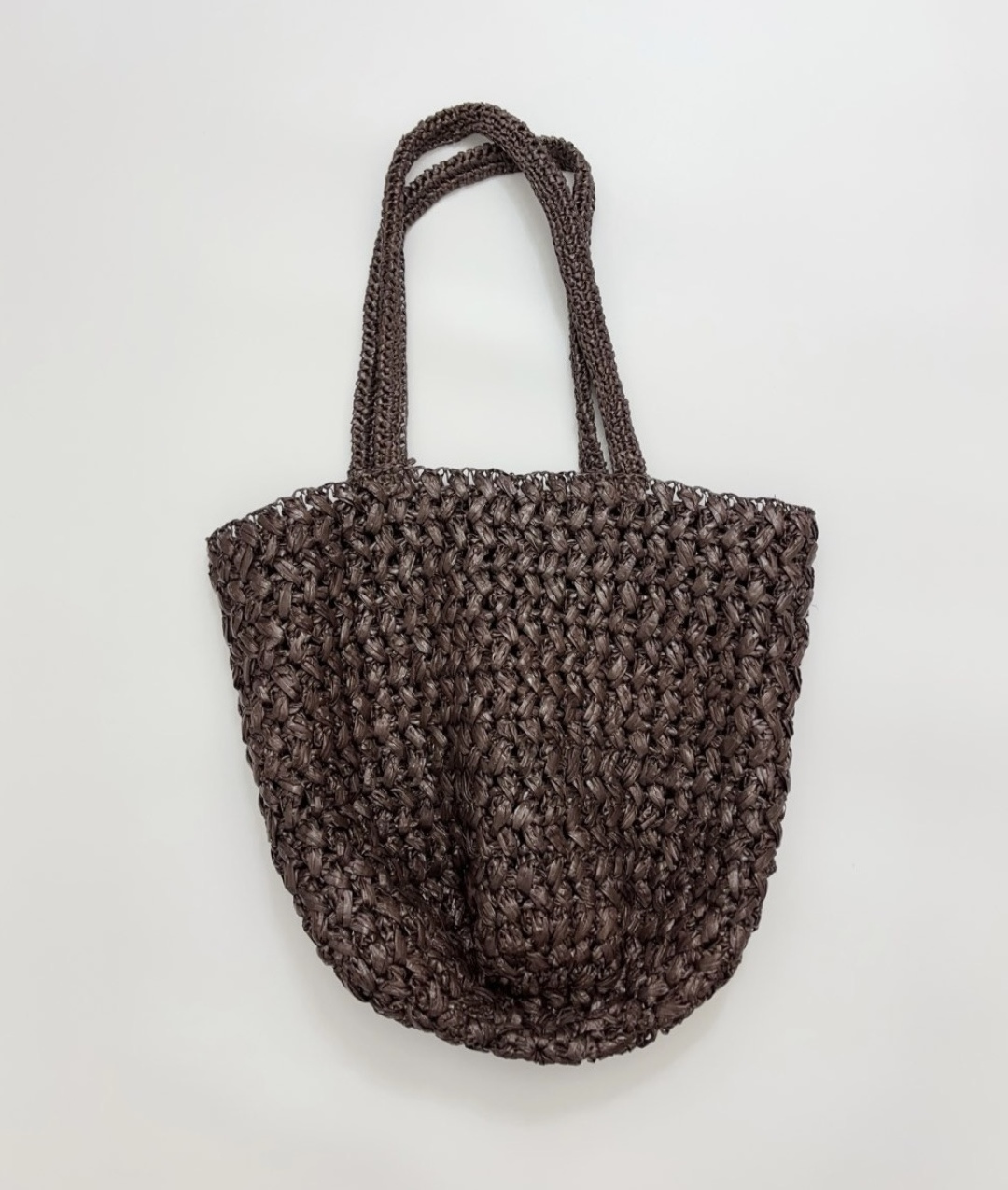 Raffia woven bag with cutout label, made of raffia.
