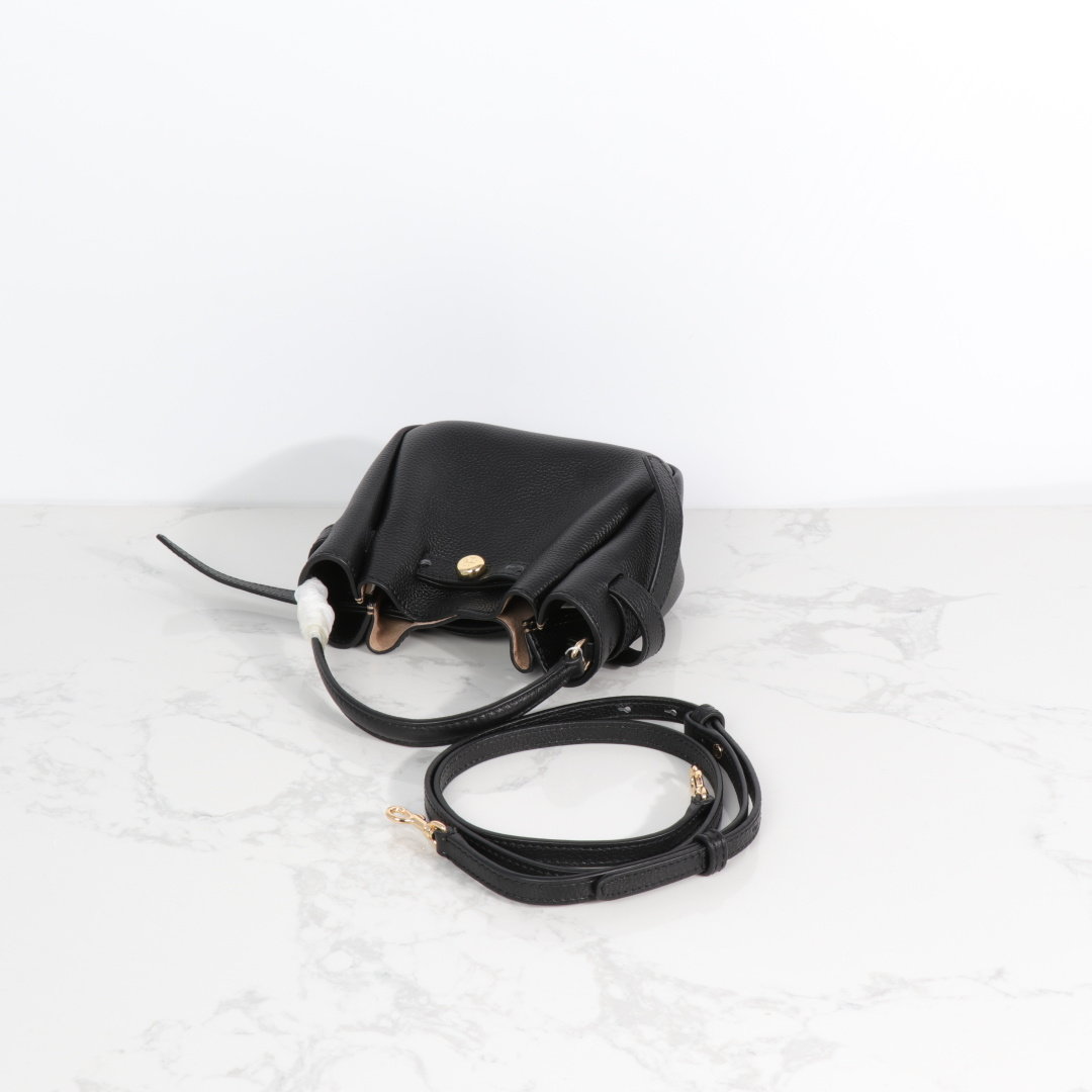 原单P380
❤️迷你miniTB新款 Romy 水桶包，精选柔软皮革，廓形灵巧，顶部巧妙收拢，富有质感。这款水桶包适合日常出行使用，轻盈灵活，包内空间宽敞，贴心配备一个口袋，方便有序收纳。配有纤细背带，并融入全新纽扣式 Logo，增添时尚亮点。可手提或斜挎，满足多样穿搭需求。磁力按扣；背带设有钉扣
尺寸18&times;8&times;15
编号179988