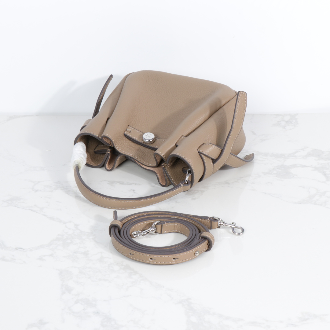 原单P380
❤️迷你miniTB新款 Romy 水桶包，精选柔软皮革，廓形灵巧，顶部巧妙收拢，富有质感。这款水桶包适合日常出行使用，轻盈灵活，包内空间宽敞，贴心配备一个口袋，方便有序收纳。配有纤细背带，并融入全新纽扣式 Logo，增添时尚亮点。可手提或斜挎，满足多样穿搭需求。磁力按扣；背带设有钉扣
尺寸18&times;8&times;15
编号179988