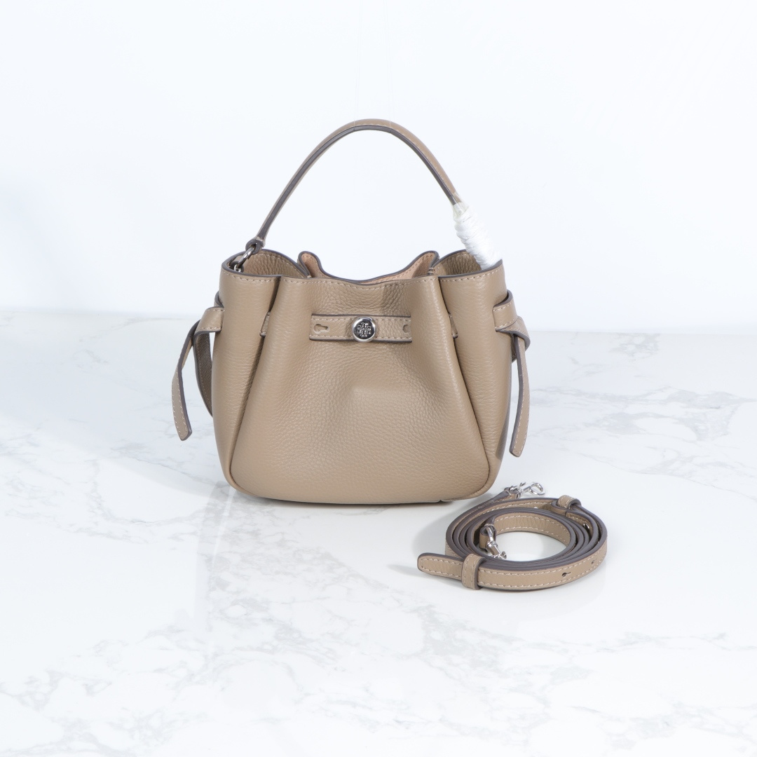 原单P380
❤️迷你miniTB新款 Romy 水桶包，精选柔软皮革，廓形灵巧，顶部巧妙收拢，富有质感。这款水桶包适合日常出行使用，轻盈灵活，包内空间宽敞，贴心配备一个口袋，方便有序收纳。配有纤细背带，并融入全新纽扣式 Logo，增添时尚亮点。可手提或斜挎，满足多样穿搭需求。磁力按扣；背带设有钉扣
尺寸18&times;8&times;15
编号179988