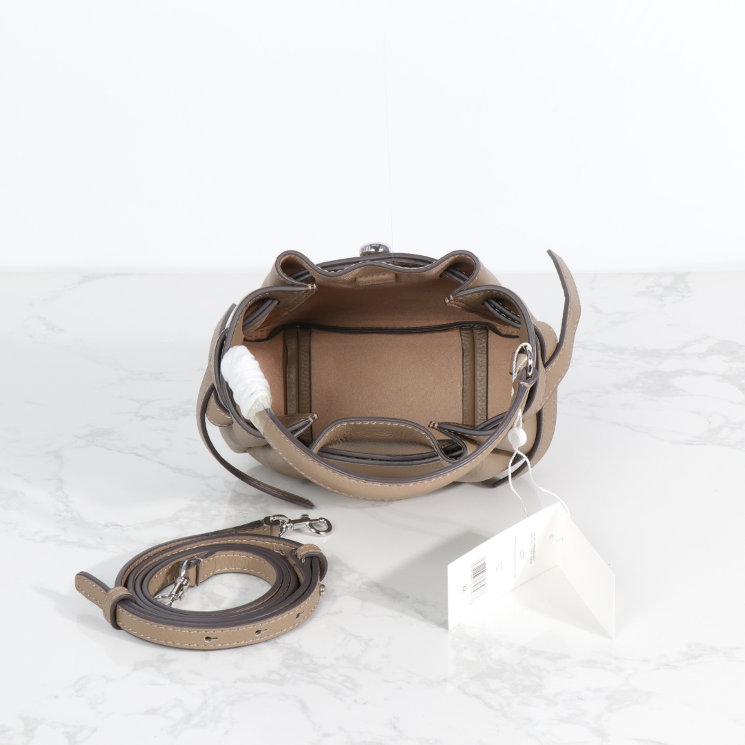 原单P380
❤️迷你miniTB新款 Romy 水桶包，精选柔软皮革，廓形灵巧，顶部巧妙收拢，富有质感。这款水桶包适合日常出行使用，轻盈灵活，包内空间宽敞，贴心配备一个口袋，方便有序收纳。配有纤细背带，并融入全新纽扣式 Logo，增添时尚亮点。可手提或斜挎，满足多样穿搭需求。磁力按扣；背带设有钉扣
尺寸18&times;8&times;15
编号179988