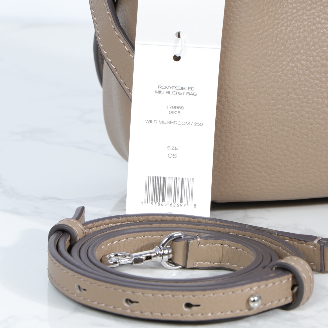 原单P380
❤️迷你miniTB新款 Romy 水桶包，精选柔软皮革，廓形灵巧，顶部巧妙收拢，富有质感。这款水桶包适合日常出行使用，轻盈灵活，包内空间宽敞，贴心配备一个口袋，方便有序收纳。配有纤细背带，并融入全新纽扣式 Logo，增添时尚亮点。可手提或斜挎，满足多样穿搭需求。磁力按扣；背带设有钉扣
尺寸18&times;8&times;15
编号179988