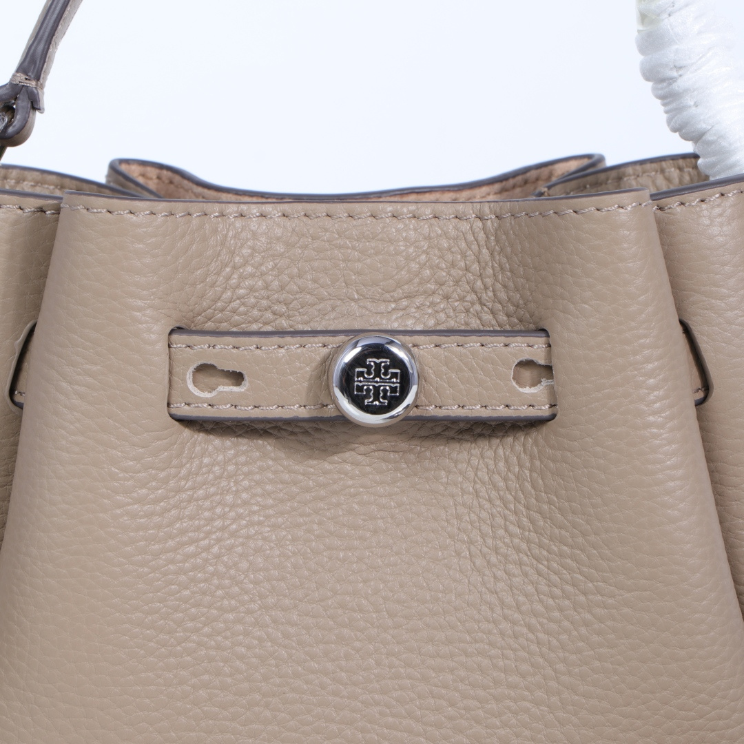 原单P380
❤️迷你miniTB新款 Romy 水桶包，精选柔软皮革，廓形灵巧，顶部巧妙收拢，富有质感。这款水桶包适合日常出行使用，轻盈灵活，包内空间宽敞，贴心配备一个口袋，方便有序收纳。配有纤细背带，并融入全新纽扣式 Logo，增添时尚亮点。可手提或斜挎，满足多样穿搭需求。磁力按扣；背带设有钉扣
尺寸18&times;8&times;15
编号179988