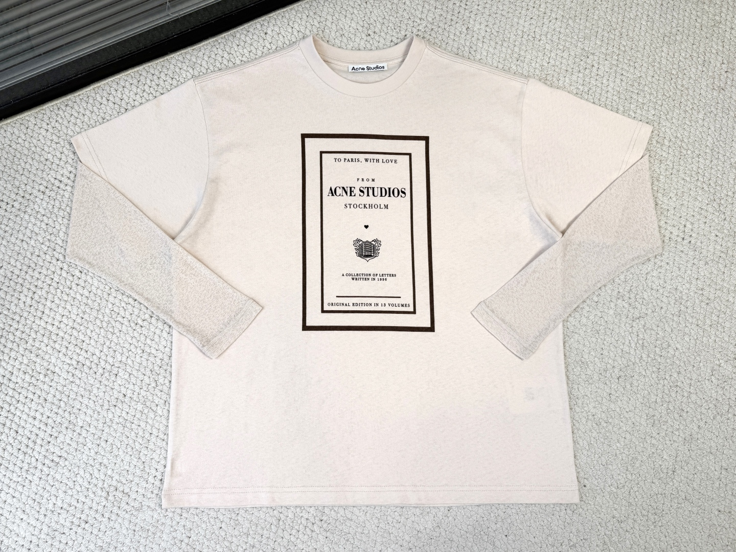 NO:833401,:Product Introduction ACE/Fake two-piece graphic T-shirt Fabric 12-count cotton plain fabric / 230G rib 32-count double yarn rib / 350G sleeves polyester rib This long-sleeved round neck T-shirt adopts a fake two-piece structure design and is made of soft cotton jersey fabric. It has a retro texture and is matched with ribbed sleeves. The front chest is decorated with seasonal graphic prints, and it is cut into a casual and unisex silhouette, with the length reaching the hips.  The long-sleeved main body is made of 12-count fine cotton plain weave fabric. The coarse yarn count is thicker and the twist is low. When woven into plain weave fabric, it will form an obvious bamboo feel and irregular texture. It deliberately abandons the smoothness and delicacy of combed cotton and retains the dry feel and slightly loose structure of a retro distressed T-shirt.  The sleeves are made of polyester ribbing, forming a complete heterogeneous splicing. The body is made of soft pure cotton, and the sleeves are made of functional chemical fiber. The polyester ribbing has natural elastic recovery ability and drape, so that the sleeve shape can rebound quickly even after strenuous activities, without causing the bulging problem that is easy to occur with cotton cuffs.  The chest letter collection pattern adopts a penetration printing process, which allows the dye molecules to completely dissolve and penetrate into the cotton fiber, and form a covalent bond with the fiber. For fabrics with uneven surface textures such as 12-count roving, penetration printing shows great advantages. The thickness and softness of the fabric in the printed area and the blank area are completely consistent, fully retaining the original dry texture and vintage texture of roving cotton.,,tees, t-shirt,19860909:产品简介 ACE/假两件图案 T 恤 面料12支精棉平纹面料 / 230G 罗纹32支双纱罗纹 / 350G 袖子涤纶罗纹 此款长袖圆领T恤采用假两件结构设计,选用柔软棉质平纹针织面料制成,具有复古质感,搭配罗纹衣袖.前胸饰有当季图案印花,剪裁为休闲中性版型,衣长及臀. 这款长袖主身选用12支精棉平纹面料,粗纱支纱线较粗、捻度较低,织成平纹布后会形成明显的竹节感与不规则肌理,刻意放弃了精梳棉的光滑细腻,保留了一种复古做旧T恤的干爽手感与微疏松结构. 衣袖则采用涤纶罗纹,形成彻底的异质拼接,衣身为柔软纯棉,袖子为功能性化纤.涤纶罗纹具有天然的弹性恢复能力与垂坠感,使袖型即使经过剧烈活动也能迅速回弹,不产生棉质袖口易出现的鼓包问题. 前胸信件合集图案采用渗透印花工艺,使染料分子完全溶解并渗入棉纤维内部,与纤维发生共价键结合.针对12支粗纱这种表面肌理凹凸不平的面料,渗透印花展现出极大优势.印花区域与空白区域的面料厚度、柔软度完全一致,完整保留了粗纱棉原始的干爽肌理与复古质感.,,tees，t-shirt,,Men's clothing