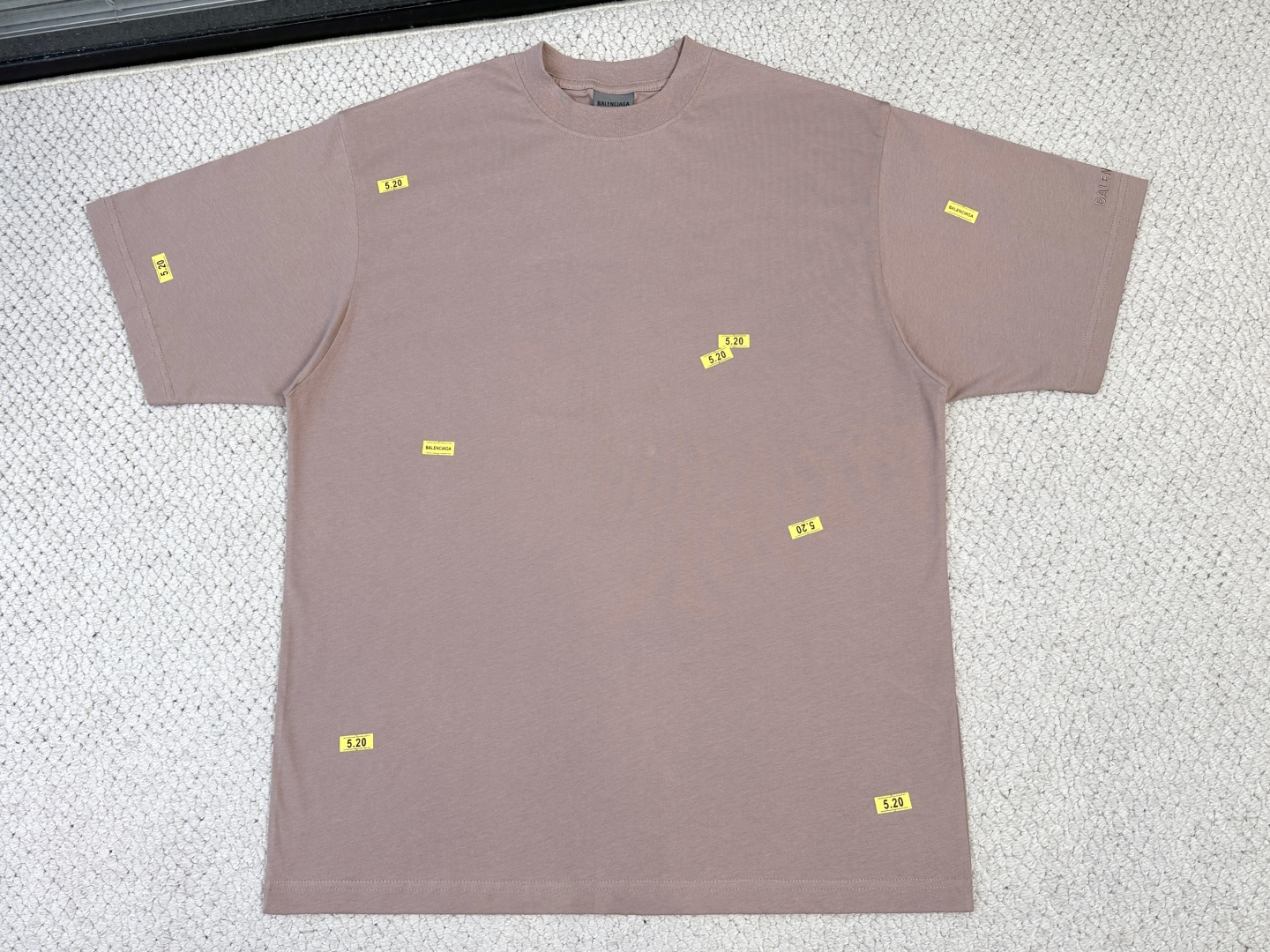 NO:840531,Balenciaga/Product Introduction Paris/520 STICKERS Medium Fit T-Shirt Fabric 24 Count Double-sided Knitted Cotton / 250G Rib 24 Count 1×1 Rib / 200G  Count 24 is a medium-to-high fine yarn count, with fine yarns and a delicate and smooth fabric surface. The double-sided knitted structure has low transverse and longitudinal elongation, strong deformation resistance, and extremely high dimensional stability. The medium-thick weight gives the fabric a soft and crisp feel; it has the unique fluffy and soft feel of double-sided knitting without losing drape support.  The artwork printing on the front and back adopts a composite process that combines environmentally friendly elastic glue and dot paste printing, and the whole piece is produced in positioning. The environmentally friendly elastic glue forms a stretchable film after solidification, with a very high elongation at break. It can be stretched synchronously with the extension of the double-sided knitted fabric. It will not crack or fall off after repeated washing, and the film thickness is thinner and feels softer. The dot paste printing is scraped in the form of dots through a high-mesh screen plate, which avoids the color block faults common in glue printing, and the color transition is natural.  The classic logo on the cuffs uses flat stitch embroidery technology. The embroidery threads are arranged in parallel and closely adjacent to cover the pattern area. The embroidery surface is smooth and smooth, with sharp and clear edges. It is suitable for expressing fine small-area text logos. It forms a contrast in craftsmanship with the glue printing on the front and back body.,,balenciaga,tees,t-shirt,19860909巴黎世家/产品简介 巴黎 / 520 STICKERS中版型T恤 面料24支双面针织棉 / 250G 罗纹24支1×1罗纹 / 200G 24支属于中高细纱支,纱线较细,布面细腻光滑.双面针织结构的横向和纵向延伸率都较低,抗变形能力强,尺寸稳定性极高.中厚克重赋予了面料柔软的挺括感；既有双面针织特有的蓬松柔软手感,又不失垂坠支撑力. 正面与背面的艺术作品印花采用环保弹力胶浆与网点浆印花相结合的复合工艺,全件对版定位制作.环保弹力胶浆固化后形成可拉伸薄膜,断裂延伸率极高,能随双面针织面料的延展同步拉伸,反复洗涤后不龟裂、不脱落,且膜厚更薄、手感更软.网点浆印花通过高目数网版以点状形式刮印,避免了胶浆印花常见的色块断层,色彩过渡自然. 袖口经典标识采用平针刺绣工艺,绣线以平行排列、紧密相邻的方式覆盖图案区域,绣面平整光滑、边缘利落清晰,适合表现精细的小面积文字徽标,与前后身的胶浆印花形成工艺质感上的对比.,,balenciaga,tees，t-shirt,,Men's clothing