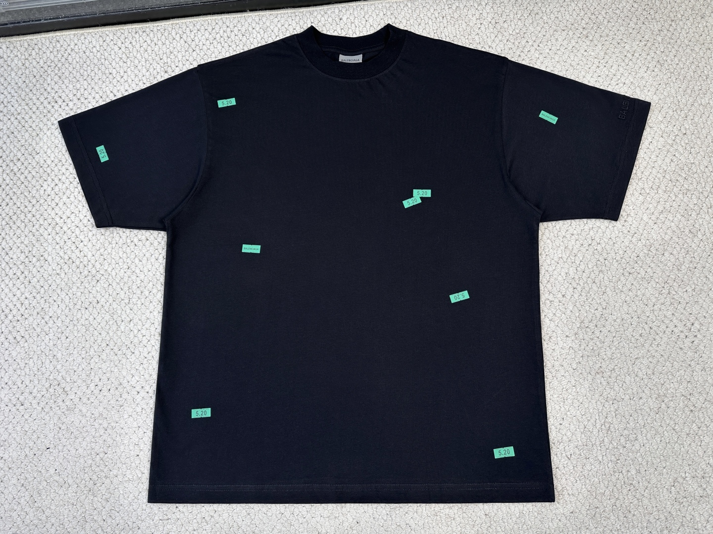 NO:840536,, Balenciaga Product Introduction Paris / 520 STICKERS Medium version T-shirt Fabric 24 counts double-sided knitted cotton / 250G Rib 24 counts 1×1 rib / 200G  Count 24 is a medium-to-high fine yarn count, with fine yarns and a delicate and smooth fabric surface. The double-sided knitted structure has low transverse and longitudinal elongation, strong deformation resistance, and extremely high dimensional stability. The medium-thick weight gives the fabric a soft and crisp feel; it has the unique fluffy and soft feel of double-sided knitting without losing drape support.  The artwork printing on the front and back adopts a composite process that combines environmentally friendly elastic glue and dot paste printing, and the whole piece is produced in positioning. The environmentally friendly elastic glue forms a stretchable film after solidification, with a very high elongation at break. It can be stretched synchronously with the extension of the double-sided knitted fabric. It will not crack or fall off after repeated washing, and the film thickness is thinner and feels softer. The dot paste printing is scraped in the form of dots through a high-mesh screen plate, which avoids the color block faults common in glue printing, and the color transition is natural.  The classic logo on the cuffs uses flat stitch embroidery technology. The embroidery threads are arranged in parallel and closely adjacent to cover the pattern area. The embroidery surface is smooth and smooth, with sharp and clear edges. It is suitable for expressing fine small-area text logos. It forms a contrast in craftsmanship with the glue printing on the front and back body.,,balenciaga,tees,t-shirt,19860909,巴黎世家 产品简介 巴黎 / 520 STICKERS中版型T恤 面料24支双面针织棉 / 250G 罗纹24支1×1罗纹 / 200G 24支属于中高细纱支,纱线较细,布面细腻光滑.双面针织结构的横向和纵向延伸率都较低,抗变形能力强,尺寸稳定性极高.中厚克重赋予了面料柔软的挺括感；既有双面针织特有的蓬松柔软手感,又不失垂坠支撑力. 正面与背面的艺术作品印花采用环保弹力胶浆与网点浆印花相结合的复合工艺,全件对版定位制作.环保弹力胶浆固化后形成可拉伸薄膜,断裂延伸率极高,能随双面针织面料的延展同步拉伸,反复洗涤后不龟裂、不脱落,且膜厚更薄、手感更软.网点浆印花通过高目数网版以点状形式刮印,避免了胶浆印花常见的色块断层,色彩过渡自然. 袖口经典标识采用平针刺绣工艺,绣线以平行排列、紧密相邻的方式覆盖图案区域,绣面平整光滑、边缘利落清晰,适合表现精细的小面积文字徽标,与前后身的胶浆印花形成工艺质感上的对比.,,balenciaga,tees，t-shirt,,Men's clothing