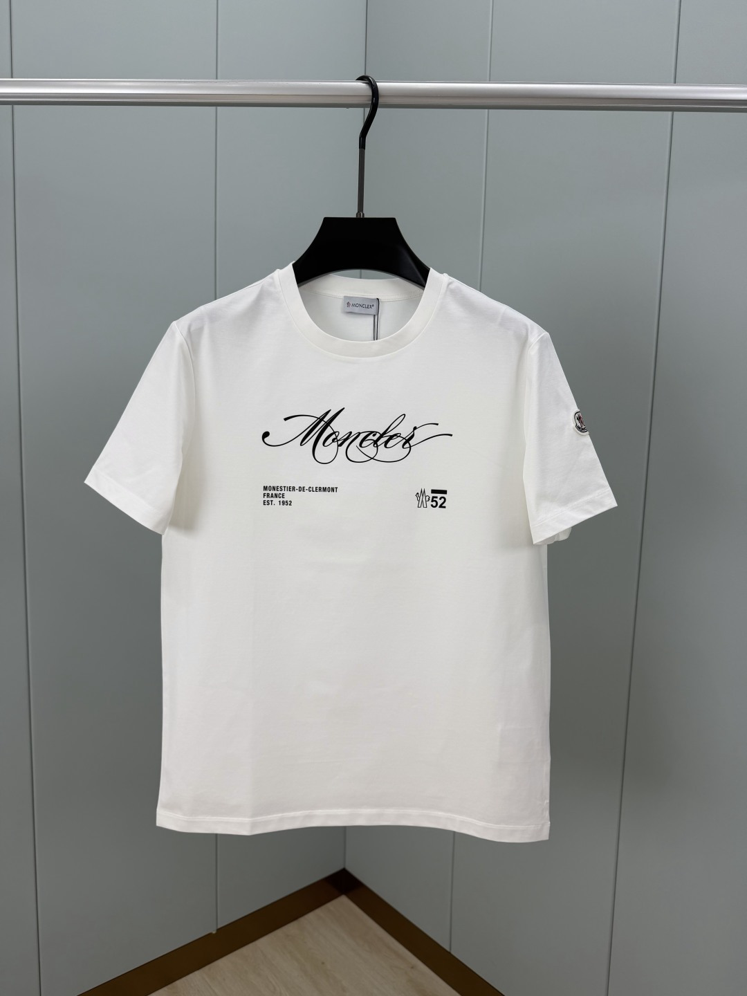 NO:830009,Moncler. SS26 new spring and summer short-sleeved T-shirt with handwritten printed logo, brand logo on the front chest + 'Monestier de Clermont France Est. 1952', simple and recognizable, classic embroidered badge on the cuffs, made of high-count and high-density 80-count double-strand mercerized cotton, the upper body is comfortable and breathable, soft, delicate and micro-elastic, high-quality fabric; color black, white  Size M-4XL,,Moncler,T-shirt,tees,t-shirt,19860909Moncler.蒙口 SS26春夏新品手写印花标识短袖T恤,正面胸前品牌标志+ “Monestier de Clermont France Est. 1952”字样,简约又有辨识度,袖口经典刺绣徽章,采用高支数高密度80支双股丝光棉,上身舒适透气、柔软细腻微弹、高品质面料； 颜色黑色、白色 尺码M-4XL,,Moncler,T-shirt,tees，t-shirt,,Men's clothing