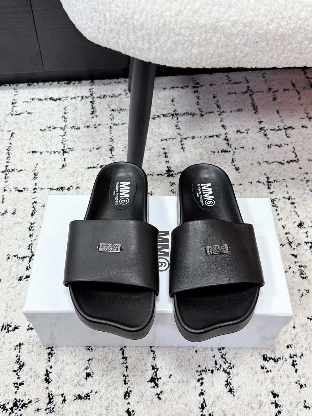 NO:711119,Mm6 Margiela 26/ Thick-soled flat-toe leather slippers adopt a classic single wide-band design with no unnecessary decoration and clean lines, suitable for a variety of wearing styles. It is easy to put on and take off, and the flat-soled design improves daily wearing comfort. The 'MM6' brand logo is printed on the upper strap, and the iconic elements enhance brand recognition.  The upper is made of fine leather fabric, which is soft to the touch and has a certain degree of stiffness. The sole is made of non-slip and wear-resistant rubber material, taking into account texture and practicality. The footbed is designed according to ergonomics, and the curvature fits the sole of the foot, making it less likely to tire your feet after long-term wear. Sheepskin upper, sheepskin lining, rubber outsole, size #35-40 (customized size 40 is non-returnable), slippers, masion margiela, masion margiela, slippers, sheepskin19860909Mm6 马吉拉 26/ 厚底平头皮革 拖鞋 采用经典的单条宽带设计,无多余装饰,线条利落,适配多种穿搭风格.穿脱便捷,平底设计提升日常穿着舒适度.鞋面带处印有“MM6”品牌标识,标志性元素强化品牌辨识度. 鞋面选用细腻的皮质面料,触感柔软且具备一定挺括度,鞋底为防滑耐磨的橡胶材质,兼顾质感与实用性.鞋床根据人体工学设计,弧度贴合足底,长时间穿着不易累脚. 鞋面羊皮 内里羊皮 大底橡胶大底 size#35-40码（40码定制不退换）,拖鞋,masion margiela,masion margiela,slippers,sheepskin,Women's Shoes