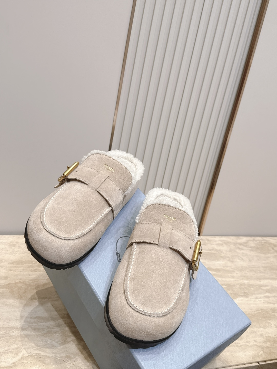 Prada 普拉达 26 秋冬皮带扣复古包头半拖毛拖 这双毛拖无疑是先锋美学与慵懒格调的惊艳融合。标志性的ALAIA皮带
