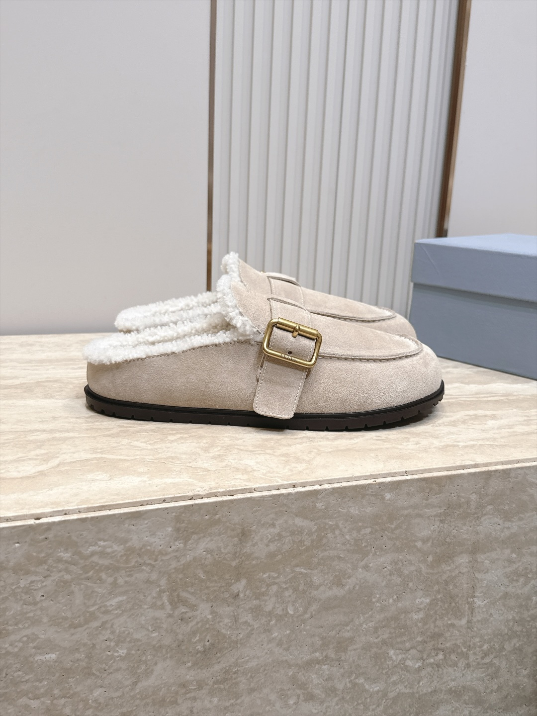 Prada 普拉达 26 秋冬皮带扣复古包头半拖毛拖 这双毛拖无疑是先锋美学与慵懒格调的惊艳融合。标志性的ALAIA皮带