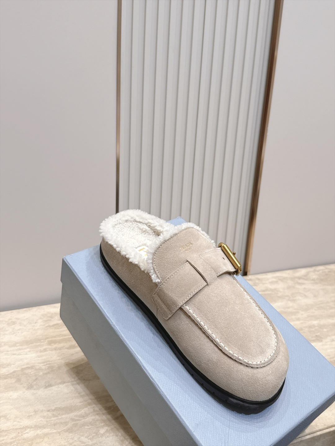 Prada 普拉达 26 秋冬皮带扣复古包头半拖毛拖 这双毛拖无疑是先锋美学与慵懒格调的惊艳融合。标志性的ALAIA皮带