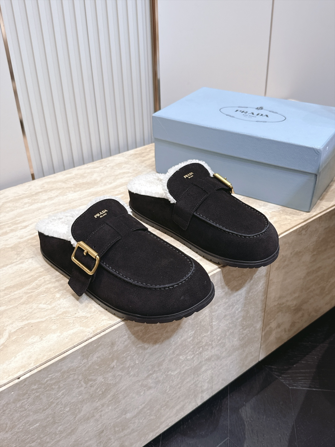 Prada 普拉达 26 秋冬皮带扣复古包头半拖毛拖 这双毛拖无疑是先锋美学与慵懒格调的惊艳融合。标志性的ALAIA皮带