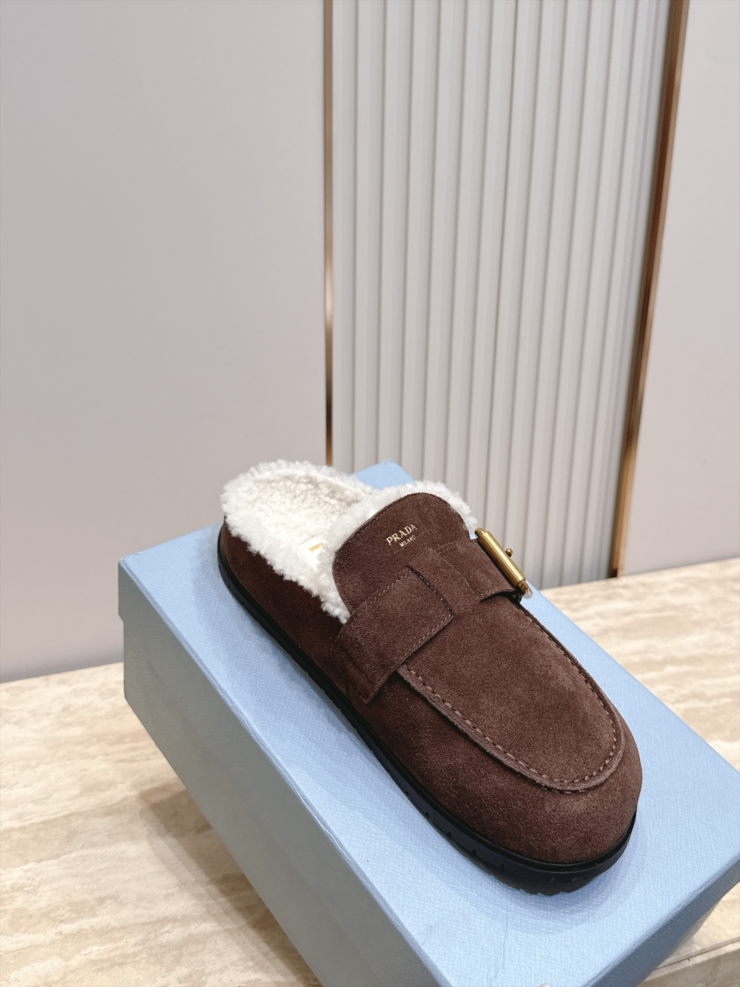 Prada 普拉达 26 秋冬皮带扣复古包头半拖毛拖 这双毛拖无疑是先锋美学与慵懒格调的惊艳融合。标志性的ALAIA皮带