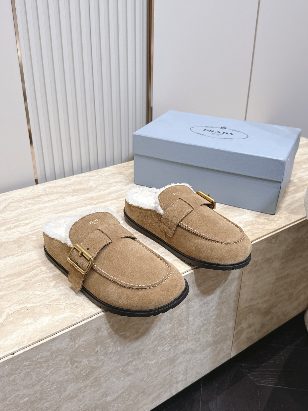 Prada 普拉达 26 秋冬皮带扣复古包头半拖毛拖 这双毛拖无疑是先锋美学与慵懒格调的惊艳融合。标志性的ALAIA皮带