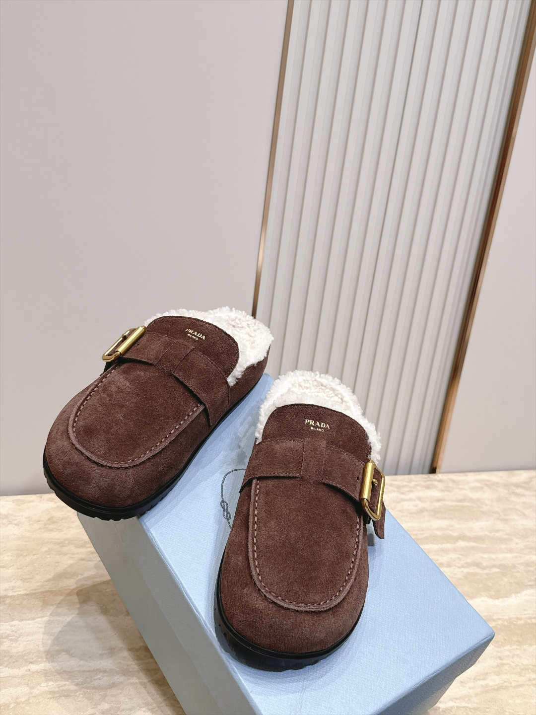 Prada 普拉达 26 秋冬皮带扣复古包头半拖毛拖 这双毛拖无疑是先锋美学与慵懒格调的惊艳融合。标志性的ALAIA皮带